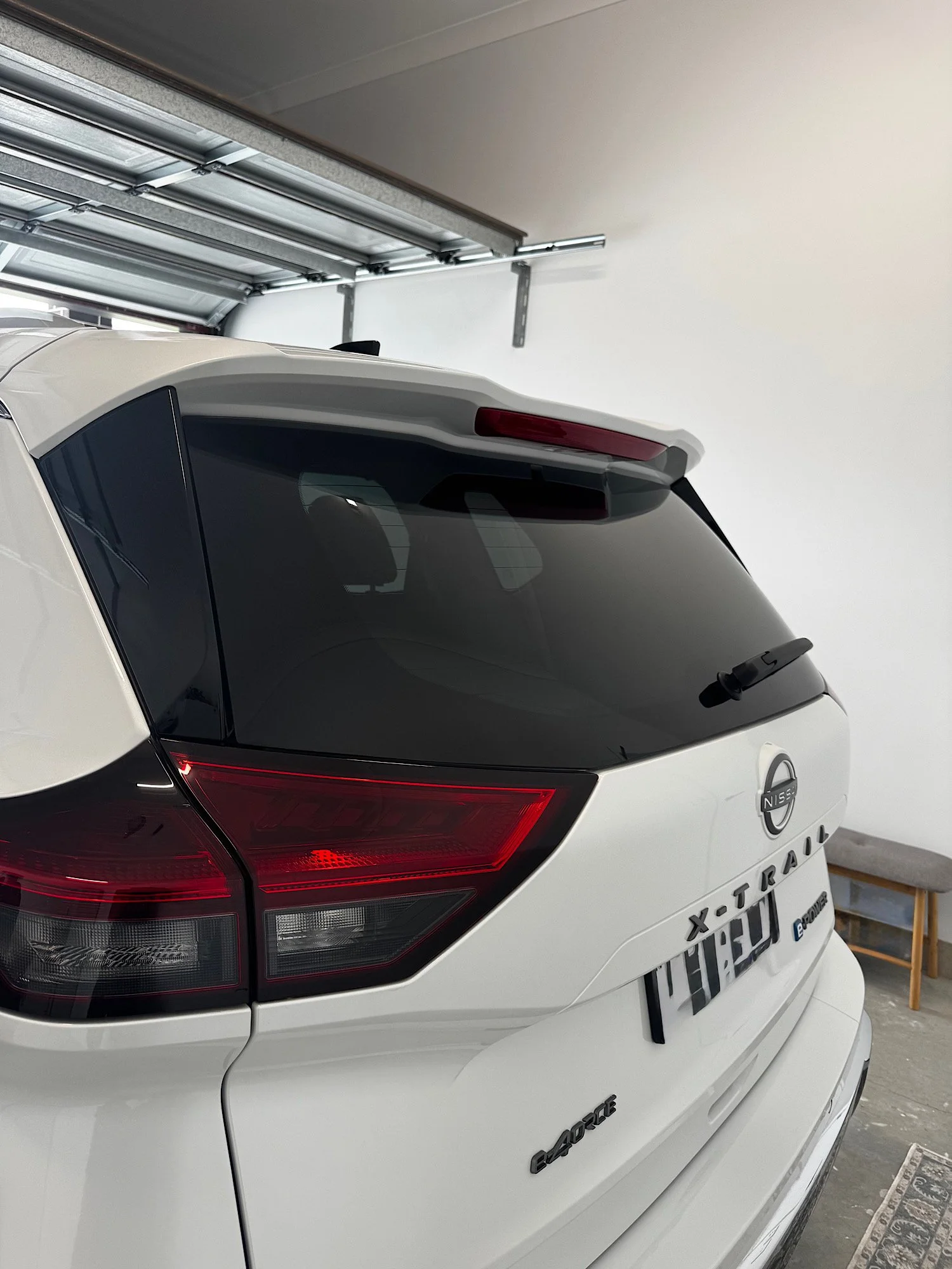 Rear view of Nissan X-Trail e-4ORCE showing tinted rear windshield with number plate removed