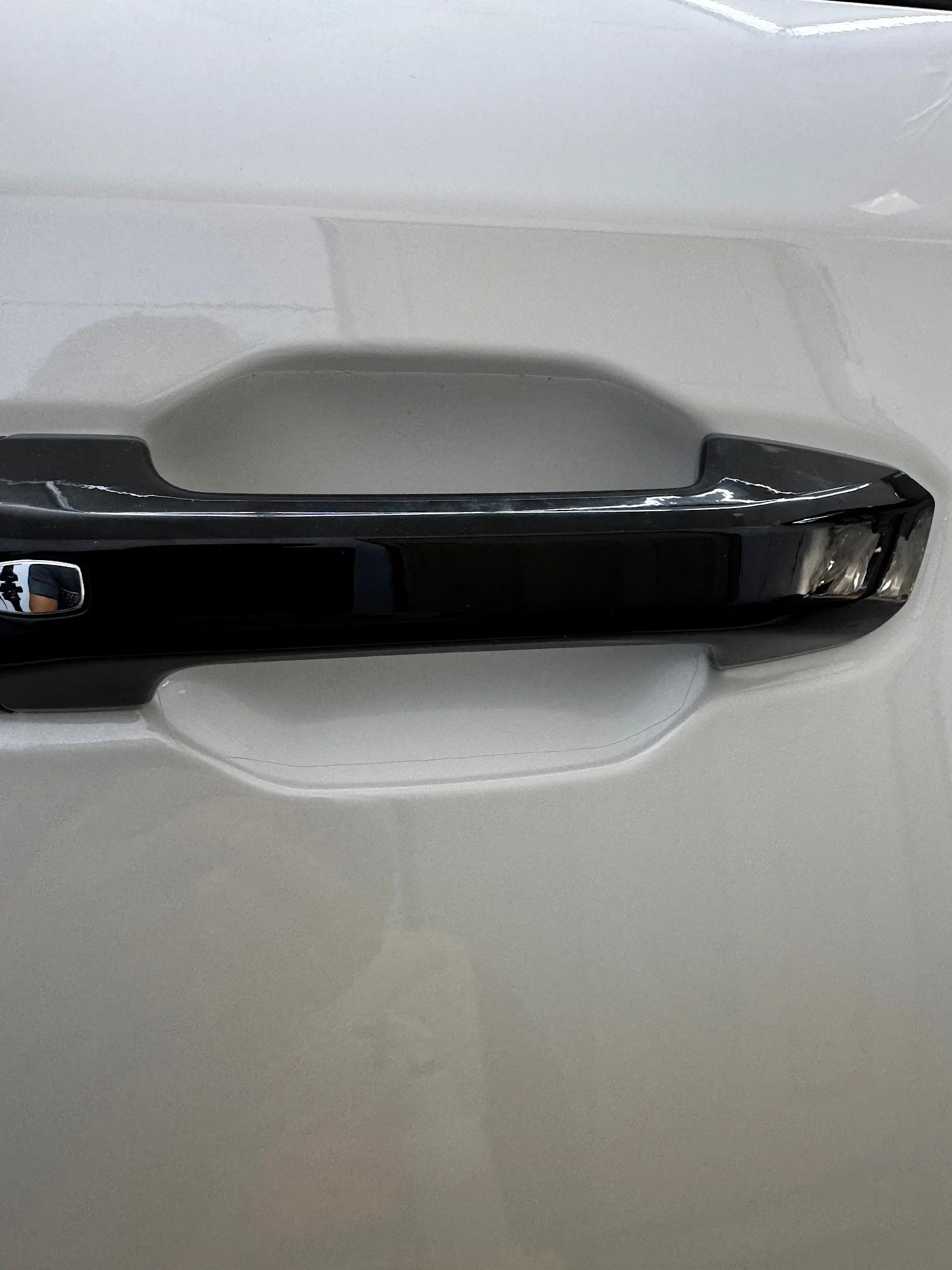 Clear paint protection film fitted behind the exterior door handle of a white 2026 LDV D90