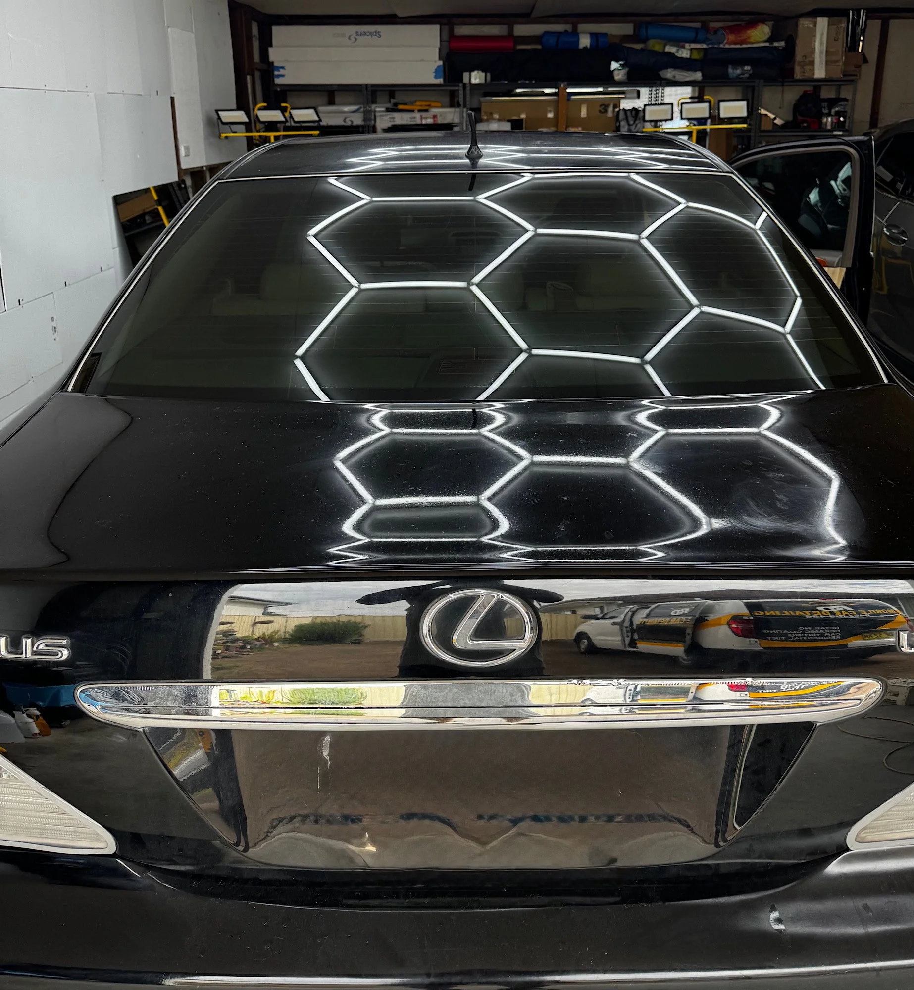 Tinted rear windscreen of a 2005 Lexus LS 430 reflecting the studio ceiling lights