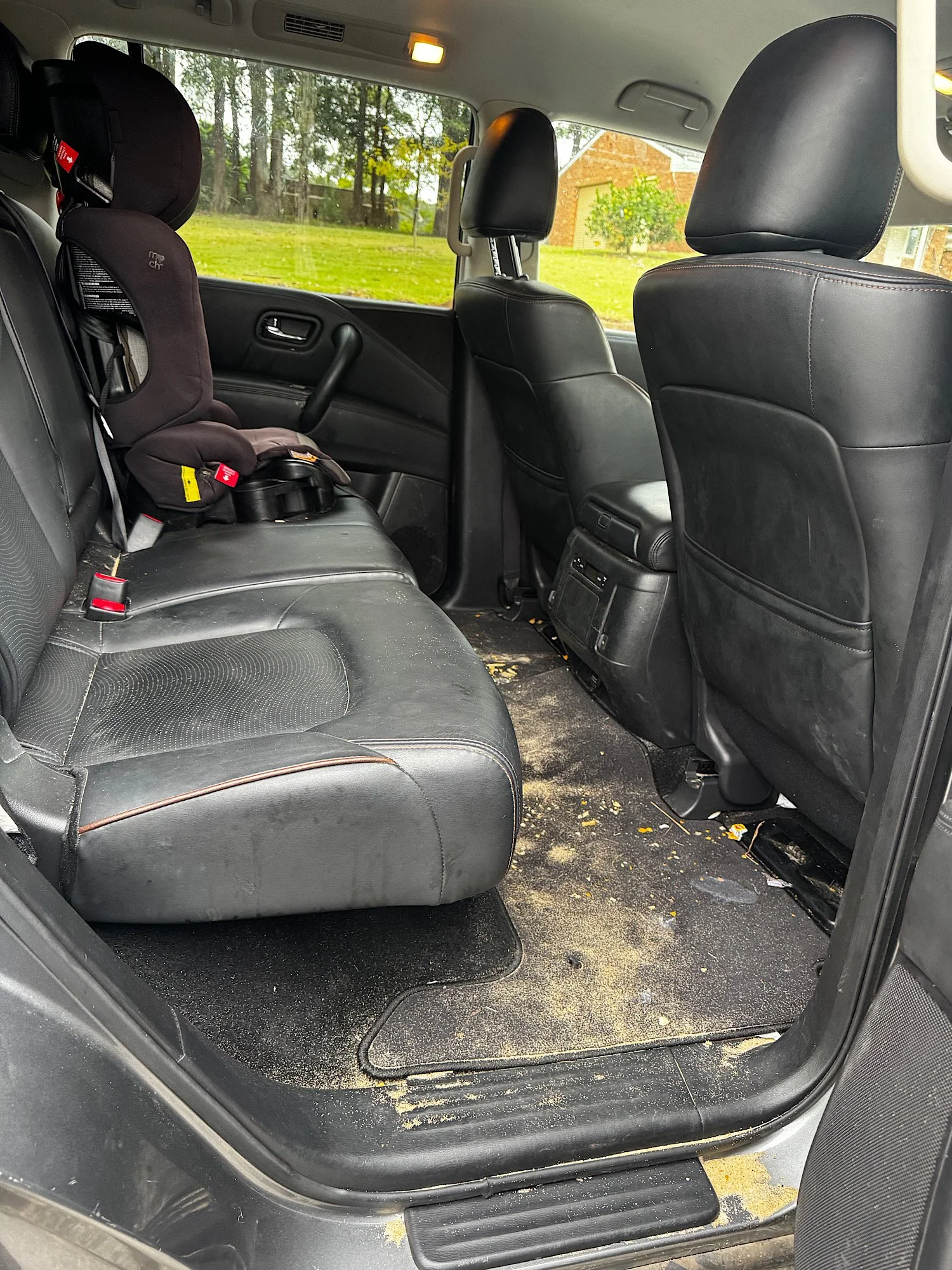 Rear seats and floor covered with sand and debris in Nissan Patrol Warrior before detailing