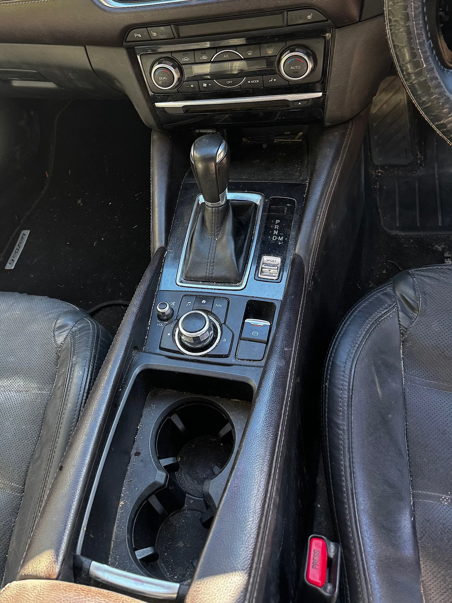 Dust buildup on center console and cup holders before detailing Mazda 6