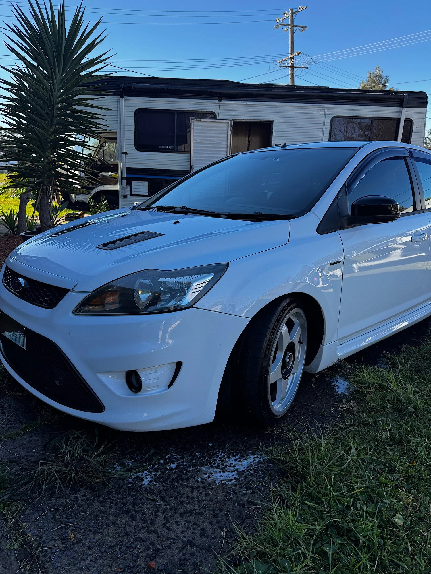 Front three-quarter view of a freshly detailed 2010 Ford Focus XR5 Turbo with custom side decals in Gwandalan NSW.
