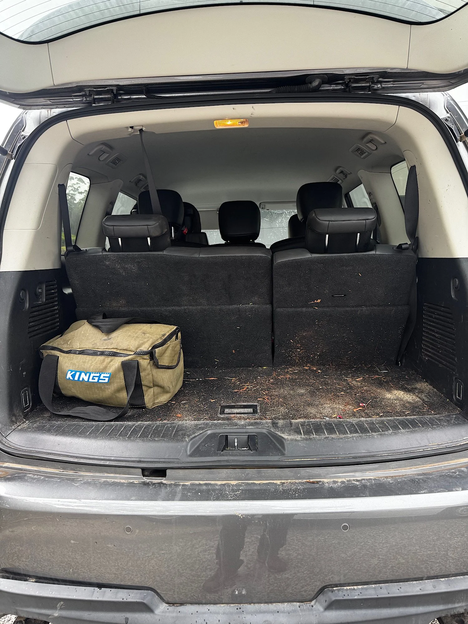 Dirty Nissan Patrol Warrior boot area with sand leaves and debris before detailing
