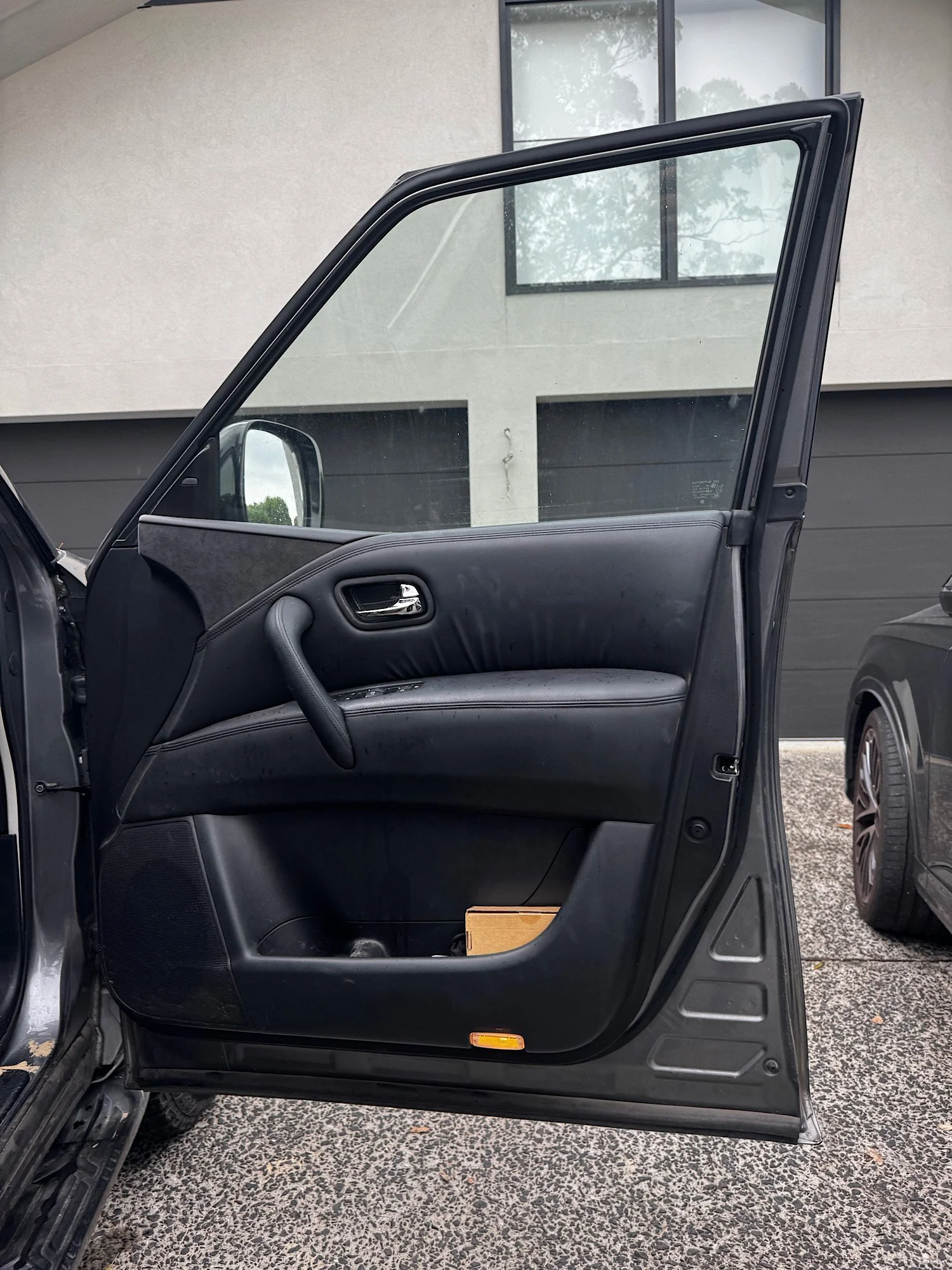 Dirty Nissan Patrol Warrior interior door panel with marks and grime before detailing