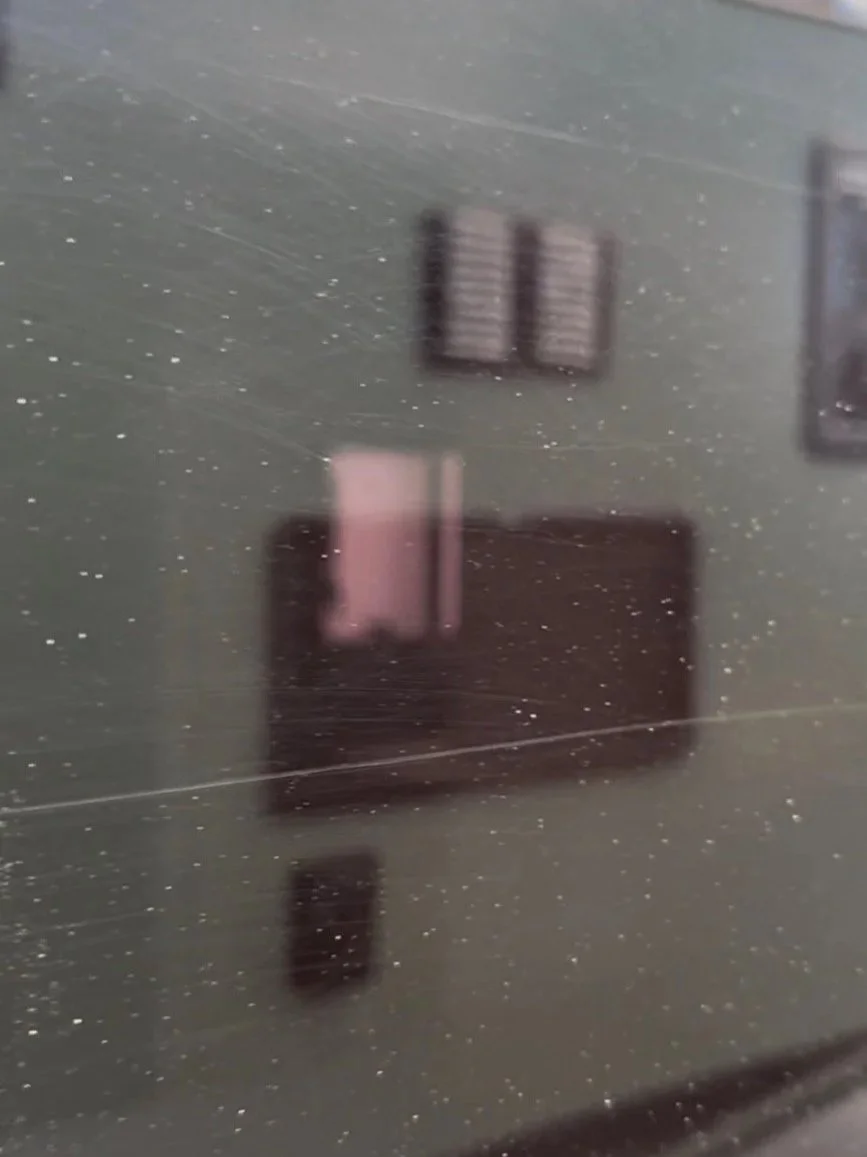 Fine scratches and surface defects visible on caravan window before correction in Erina NSW