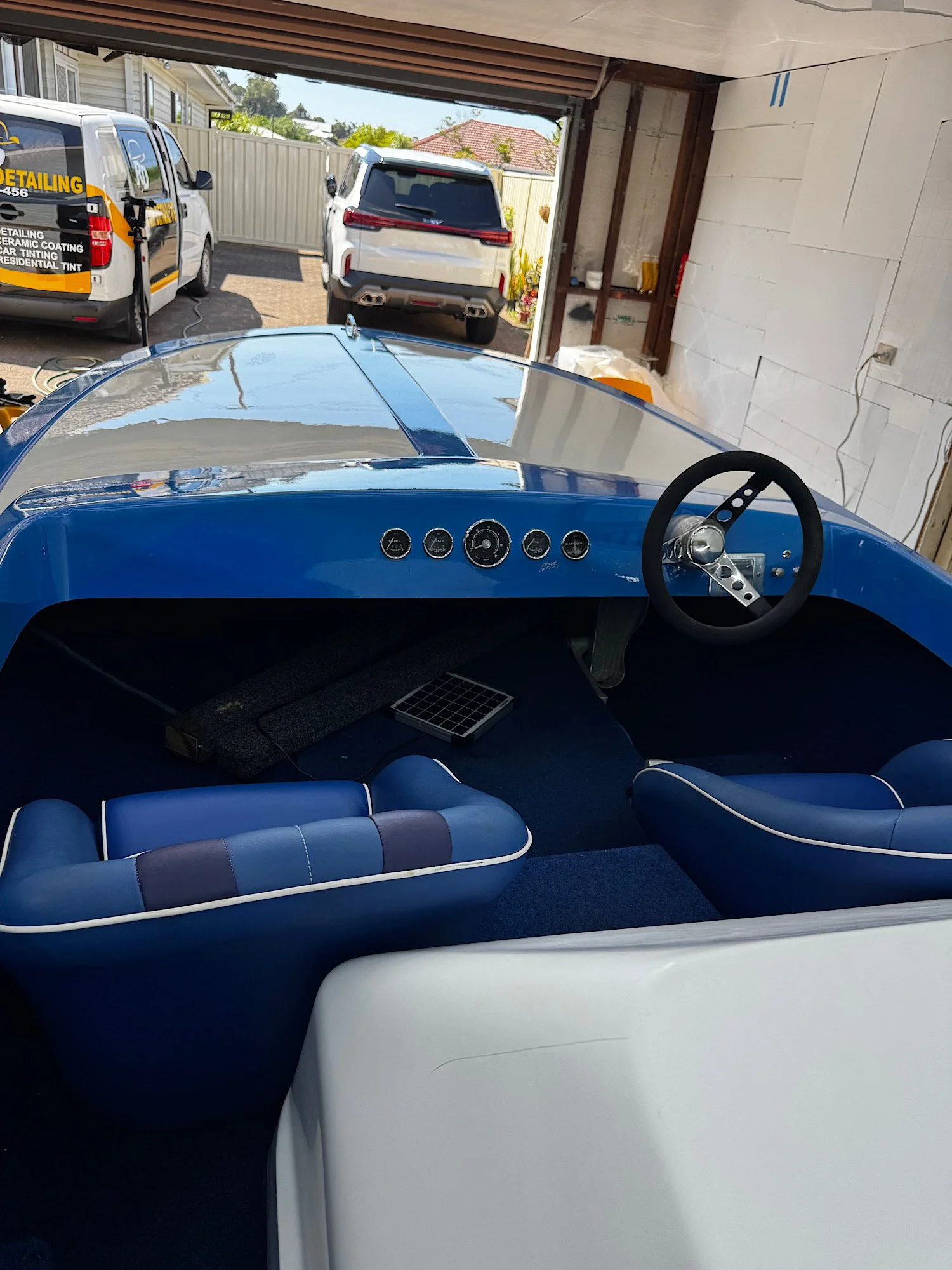 Boat cockpit showing the blue dashboard with PPF covering the surrounding surfaces around the steering wheel and gauges.
