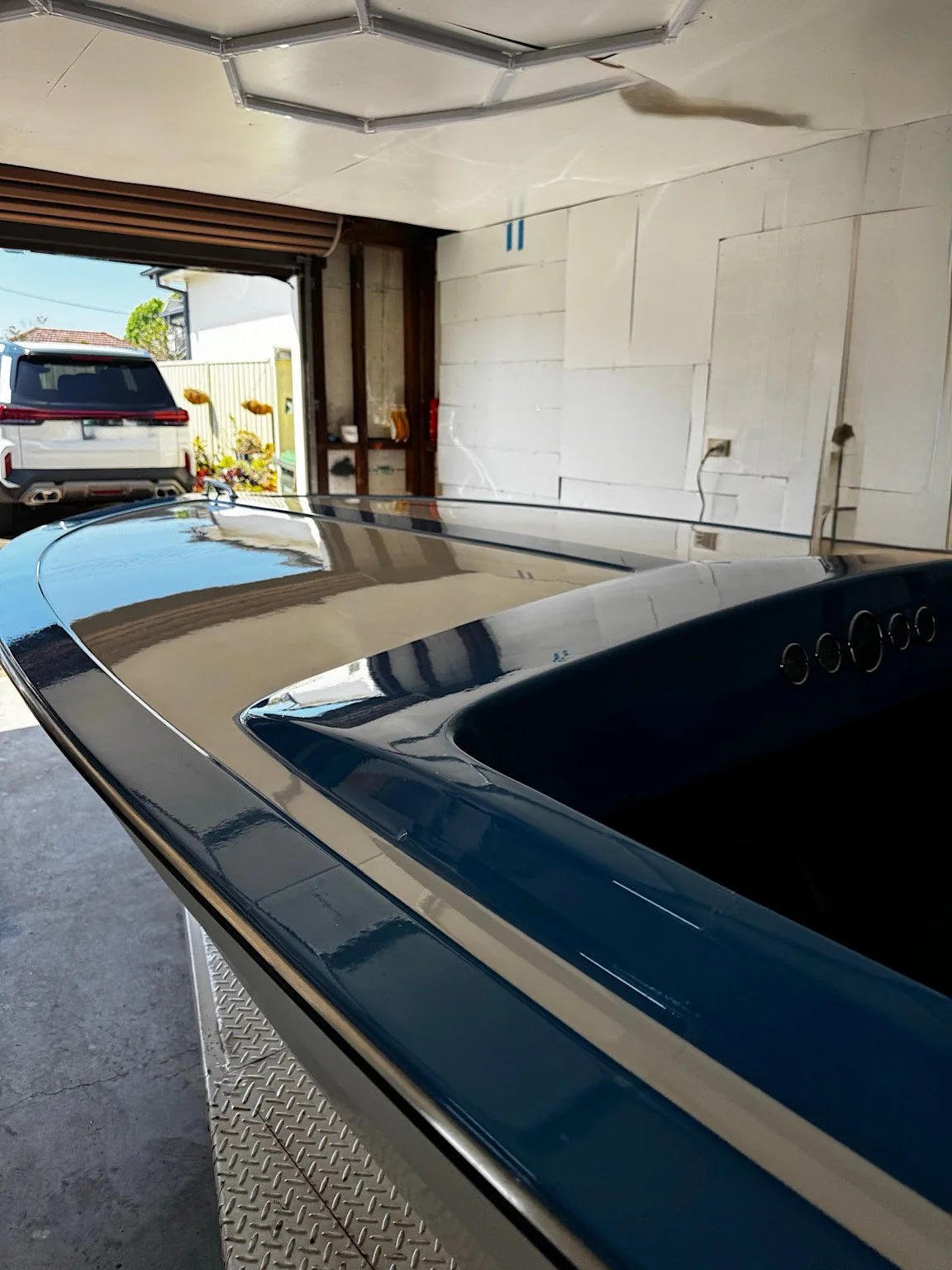 Close-up of the boat’s glossy blue-and-white upper surfaces after paint correction and PPF application.