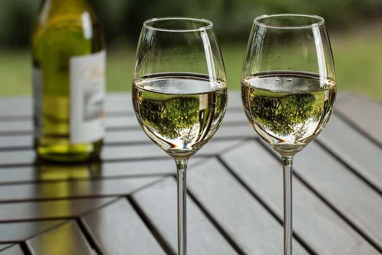 Two glasses of white wine on an outdoor table