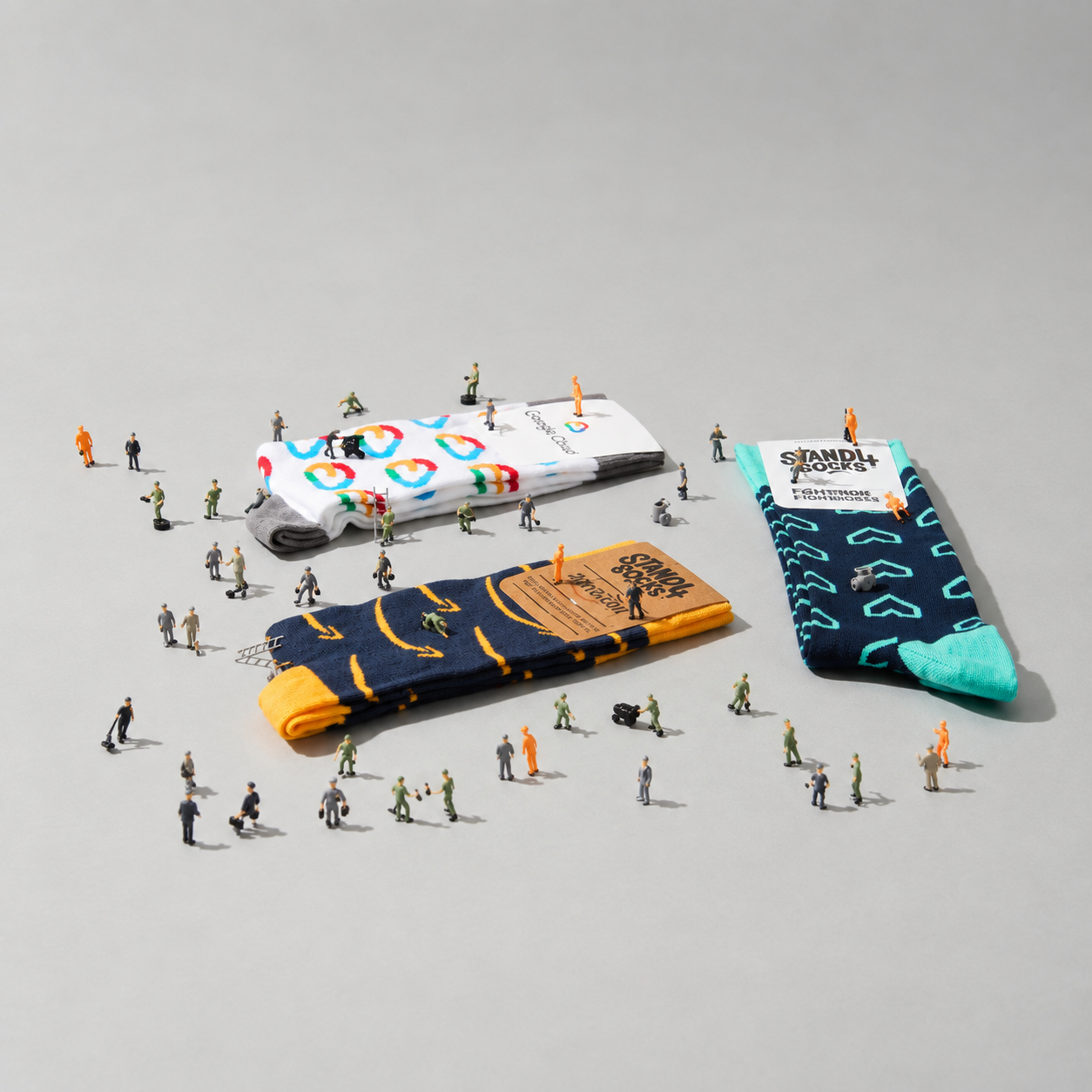 Three pairs of custom branded company socks in Stand4Socks packaging, surrounded by miniature model figures