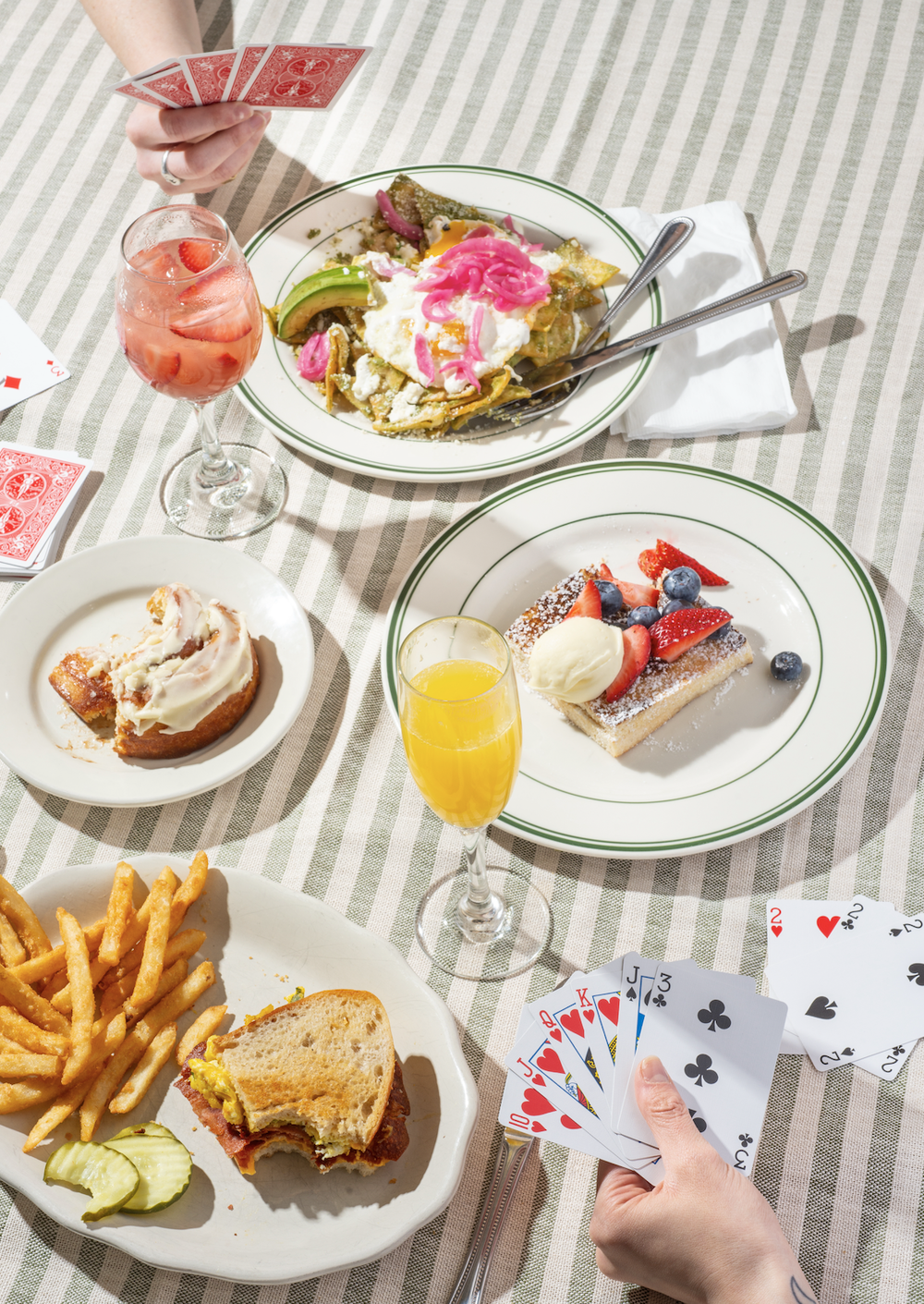 Summer brunch with playing cards on a striped tablecloth