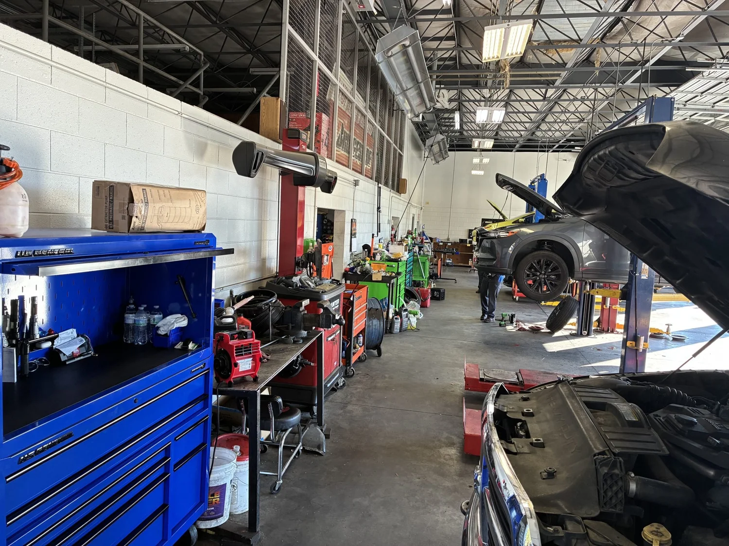 Inside the Central Automotive shop with vehicle lifts and a blue tool chest