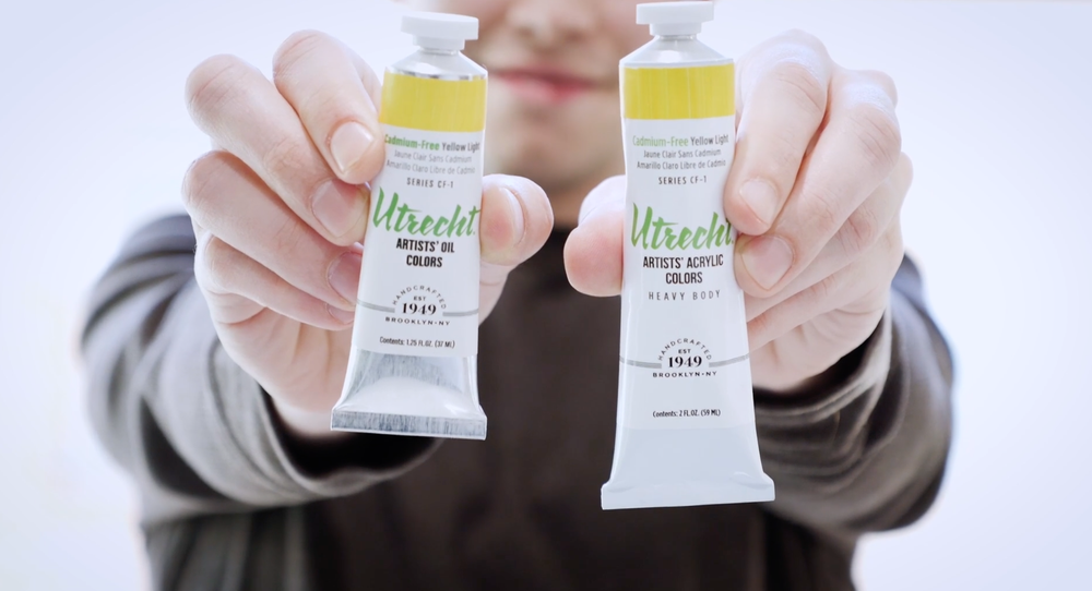 Hands holding two tubes of Utrecht oil color