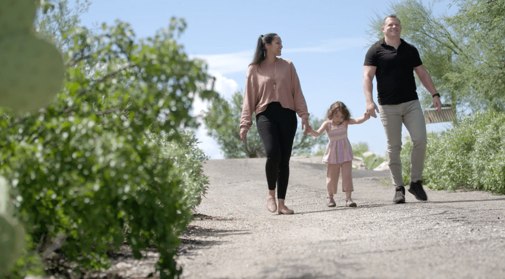 Robert and his wife walking with their daughter