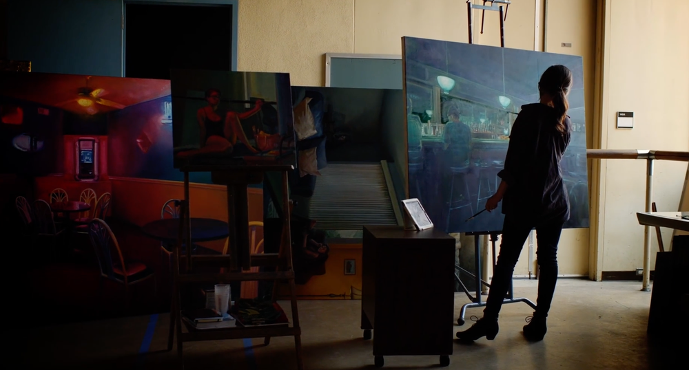 Artist at work in a studio of large canvases