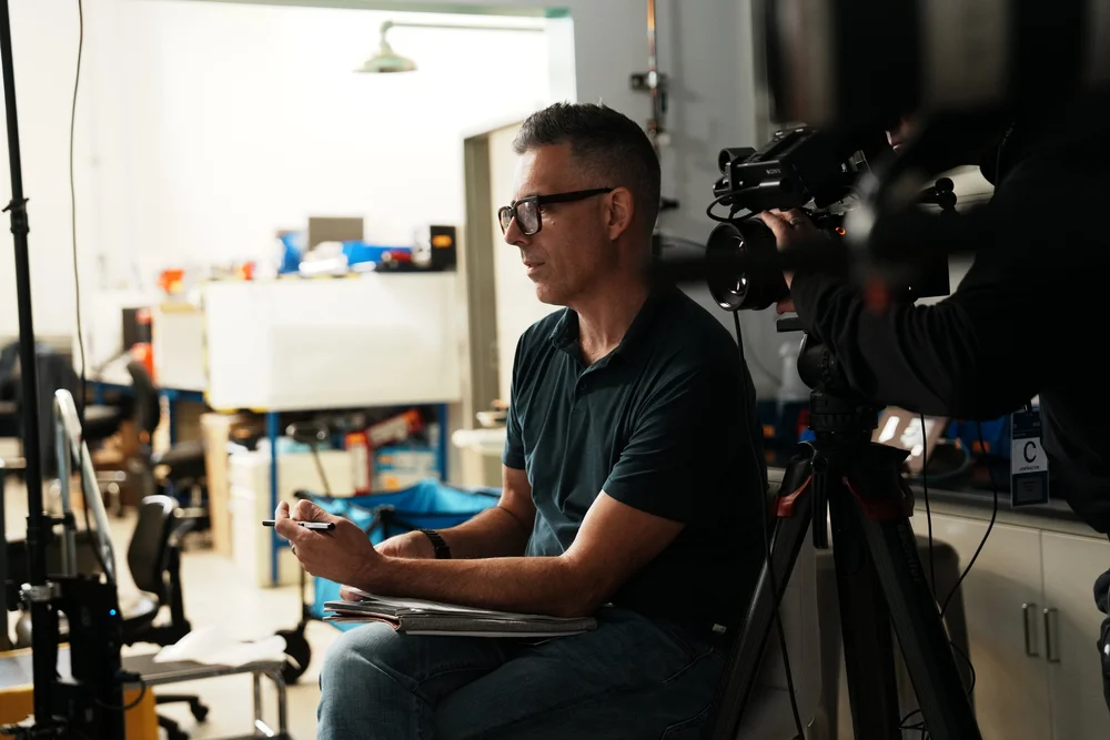 John Versical running camera on a lab interview