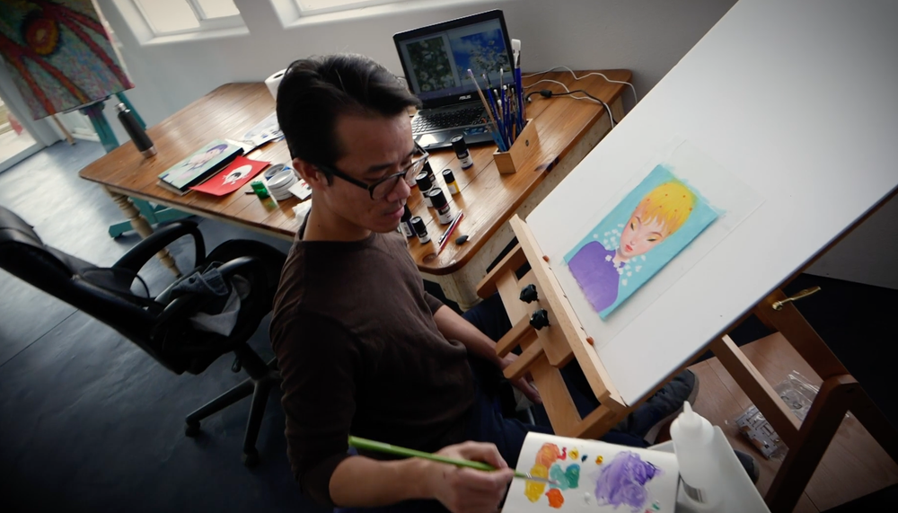 Bao Pham painting at his studio desk