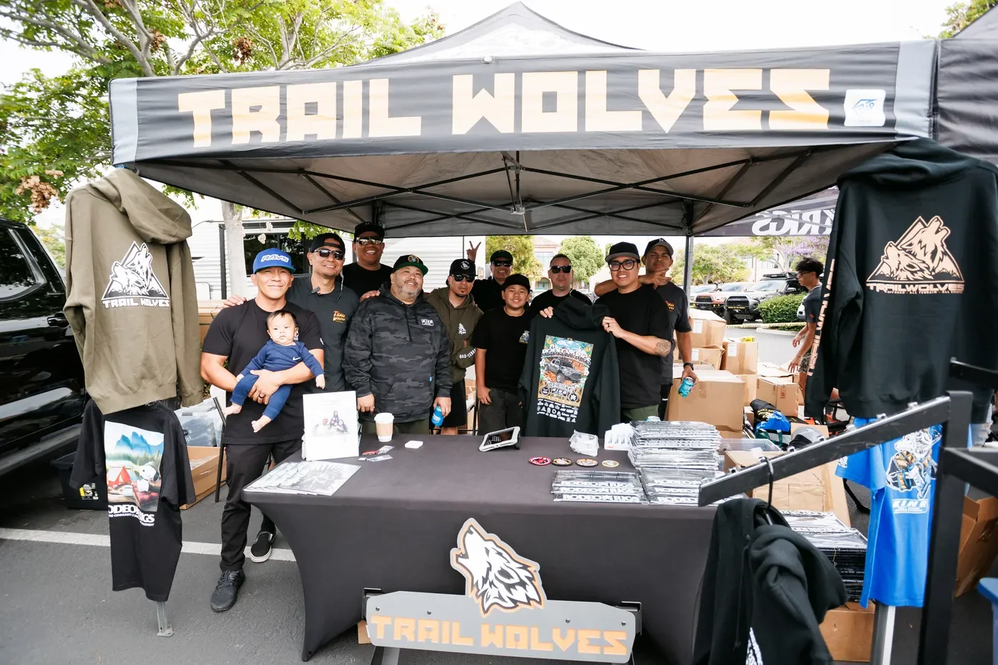 The Trail Wolves crew behind their booth on vendor row, merch racked and stacked