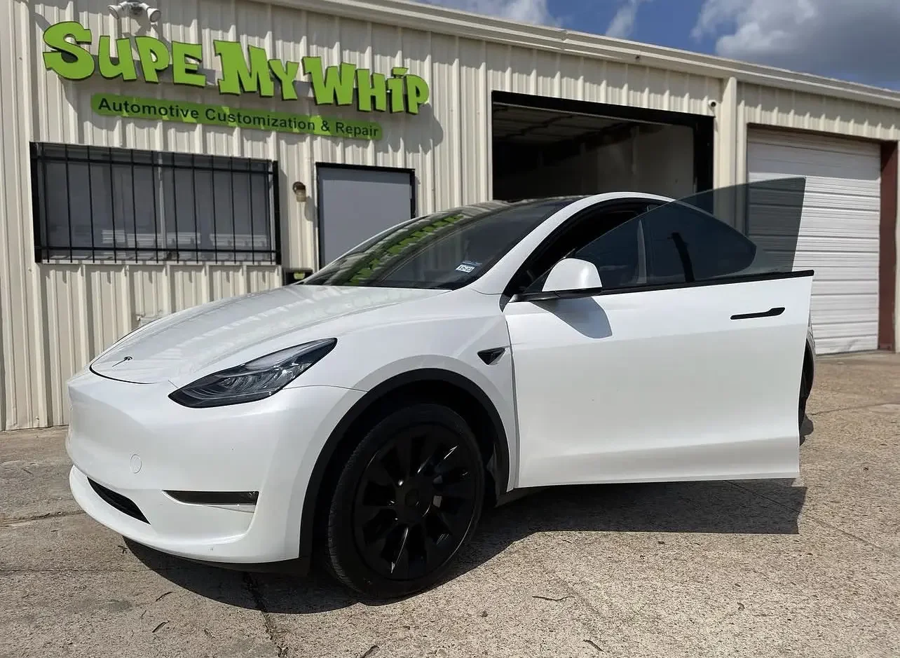 White Tesla Model Y outside the Supe My Whip automotive studio