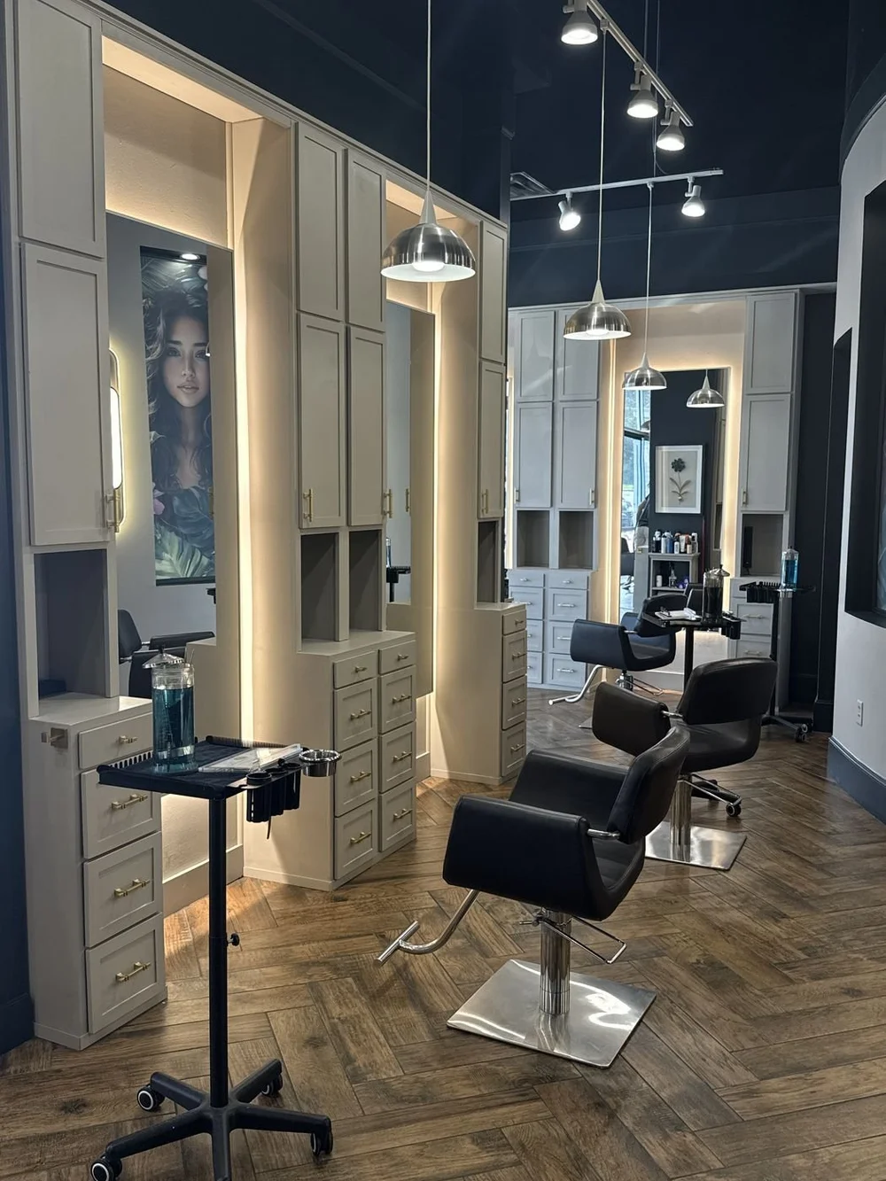 Backlit styling stations with herringbone floors at the Stone Oak salon