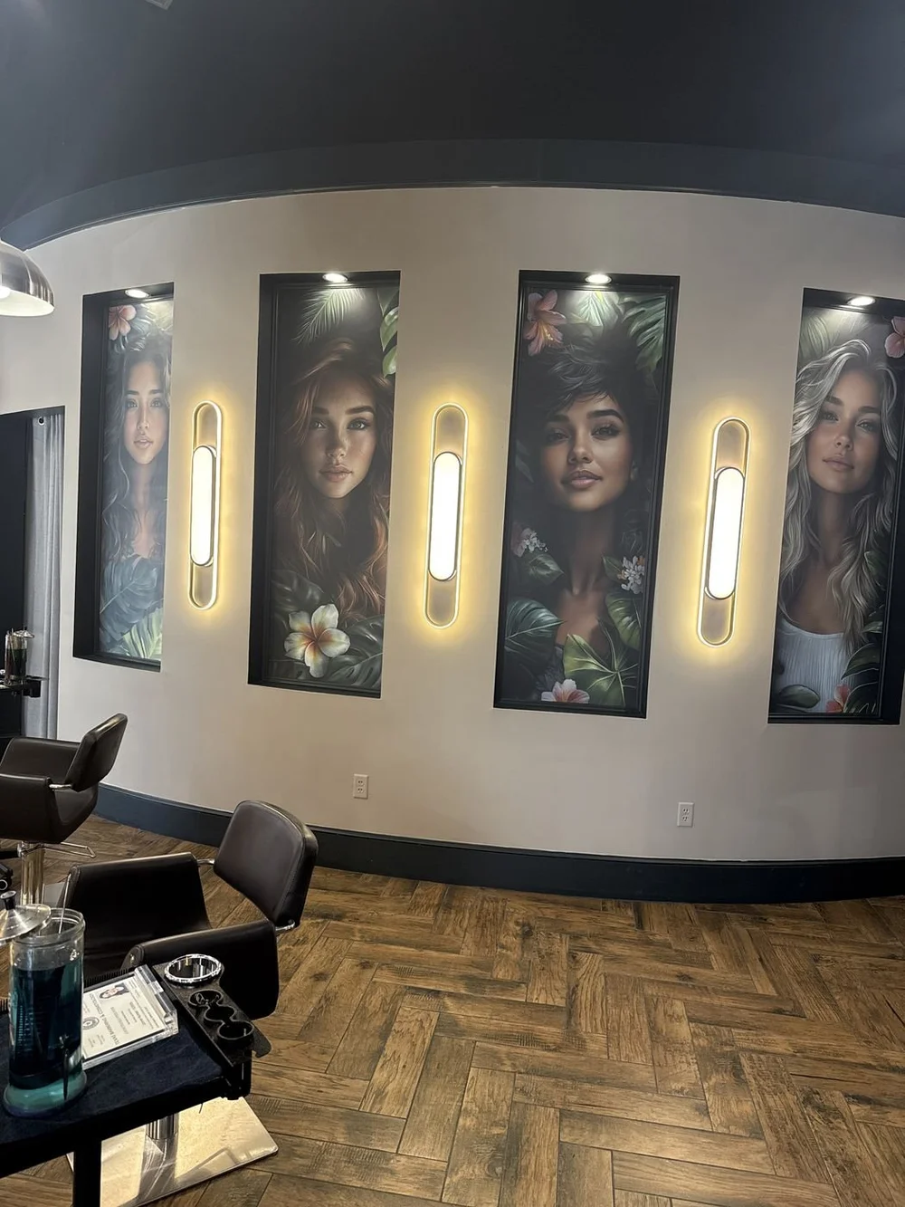 Illuminated portrait wall and gold sconces at the Stone Oak salon