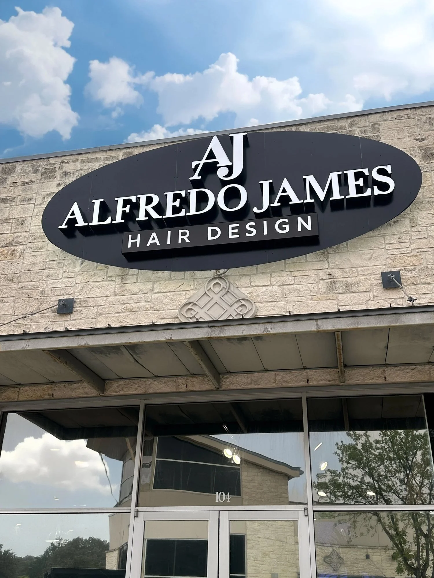Letrero de Alfredo James Hair Design sobre la entrada del salón de Stone Oak en Blanco Road