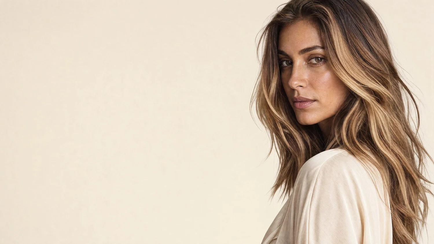 Mujer con balayage caramelo, largo y natural, en ondas suaves