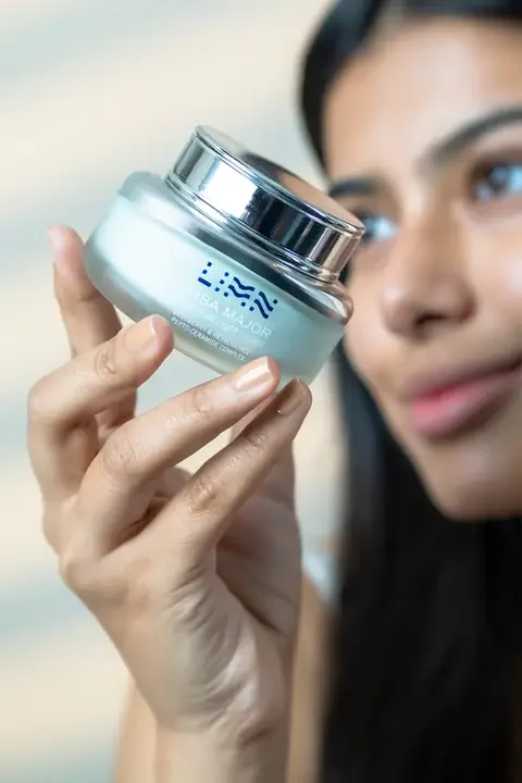Model holding a jar of LIMN Ursa Major up to the light