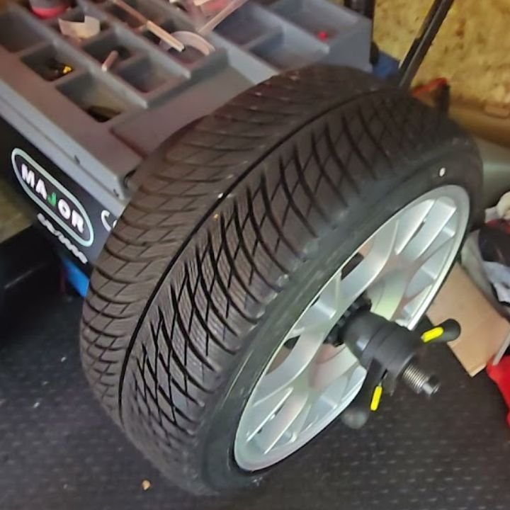 TIA-certified technician using a digital wheel balancer for mobile on-site service