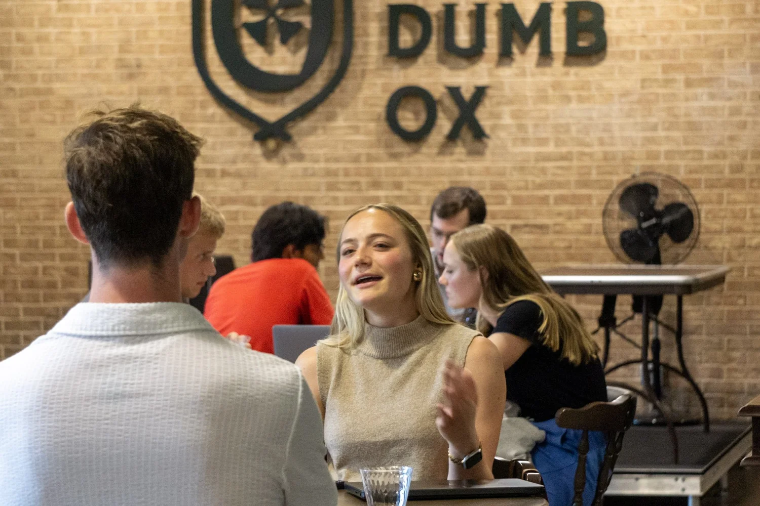 A student talking with a reviewer beneath the Dumb Ox sign