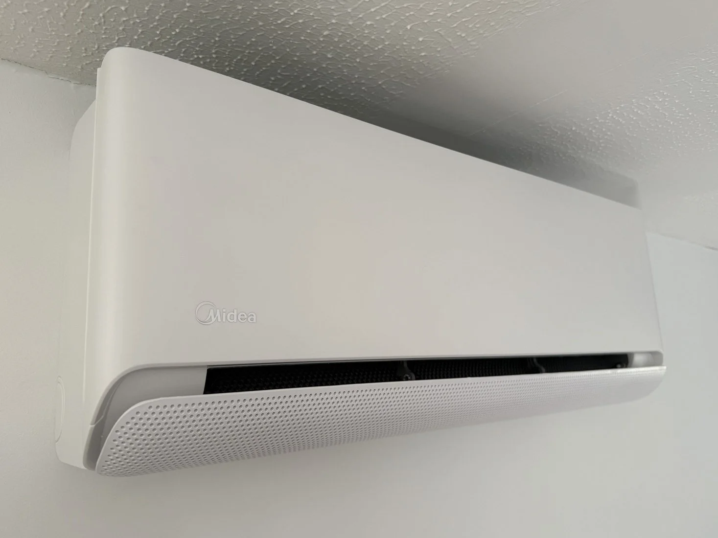 White wall-mounted air conditioning unit in a neutral room