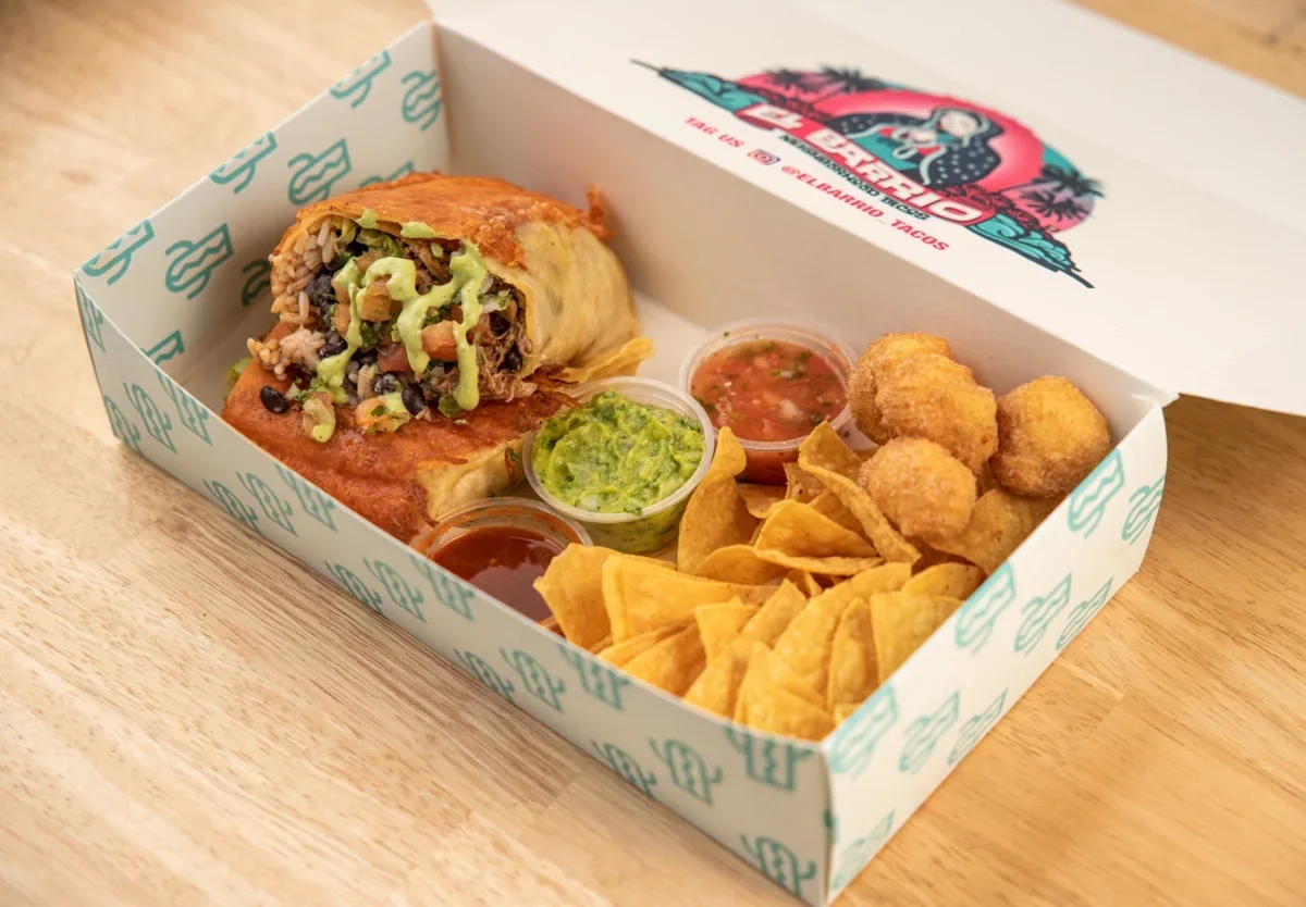 A burrito and sides in an original El Barrio Neighborhood Tacos box