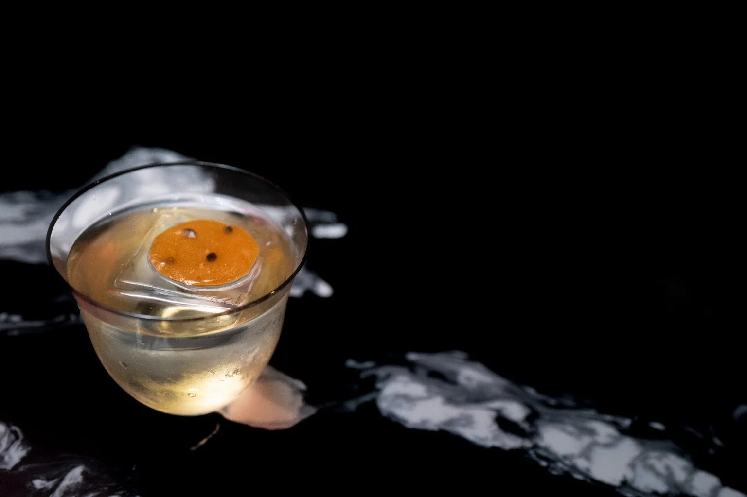 Tokyo Noir cocktail with a round orange garnish, photographed by Jesse Duron