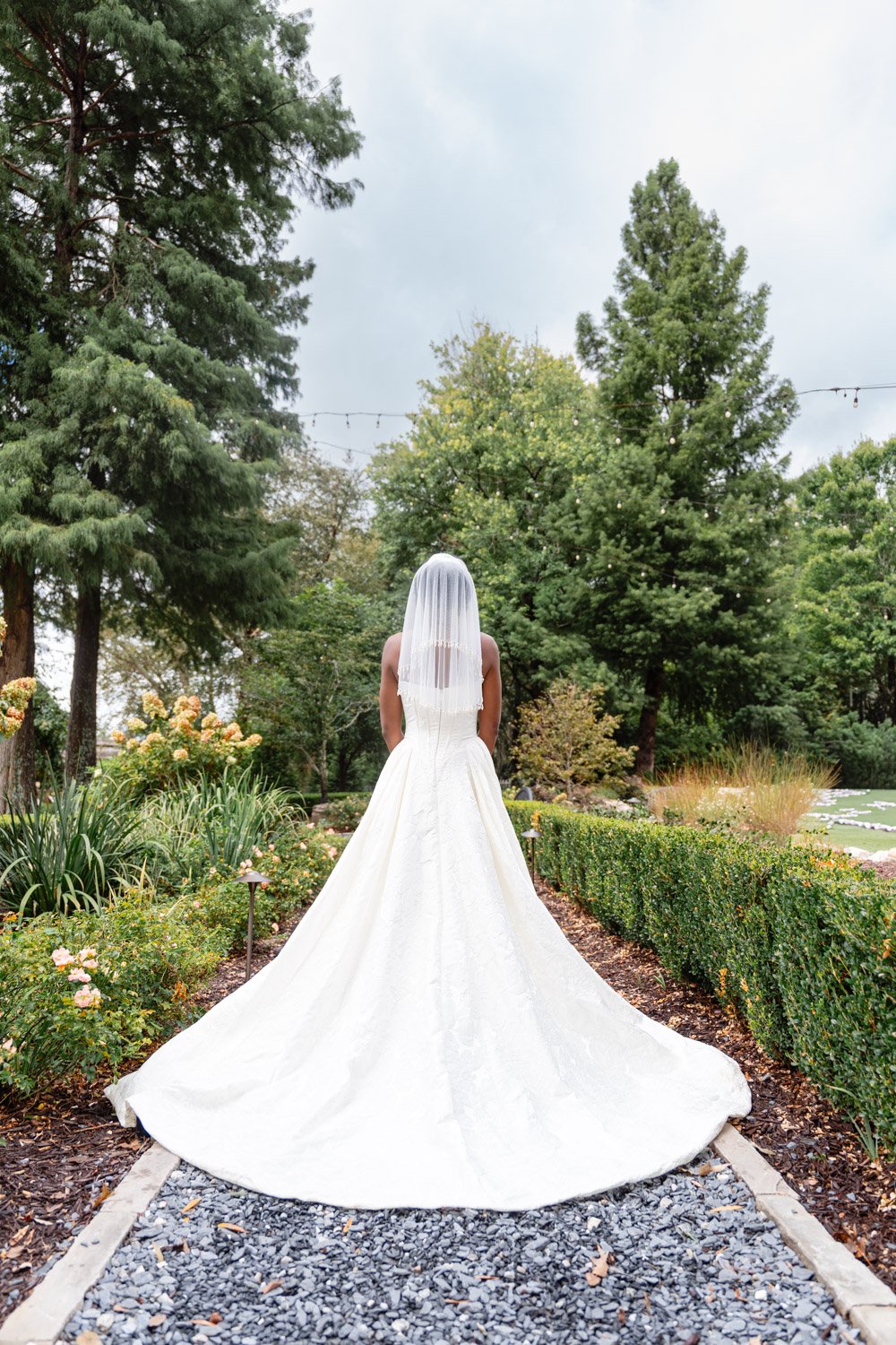 Bridal gown and veil along a garden path