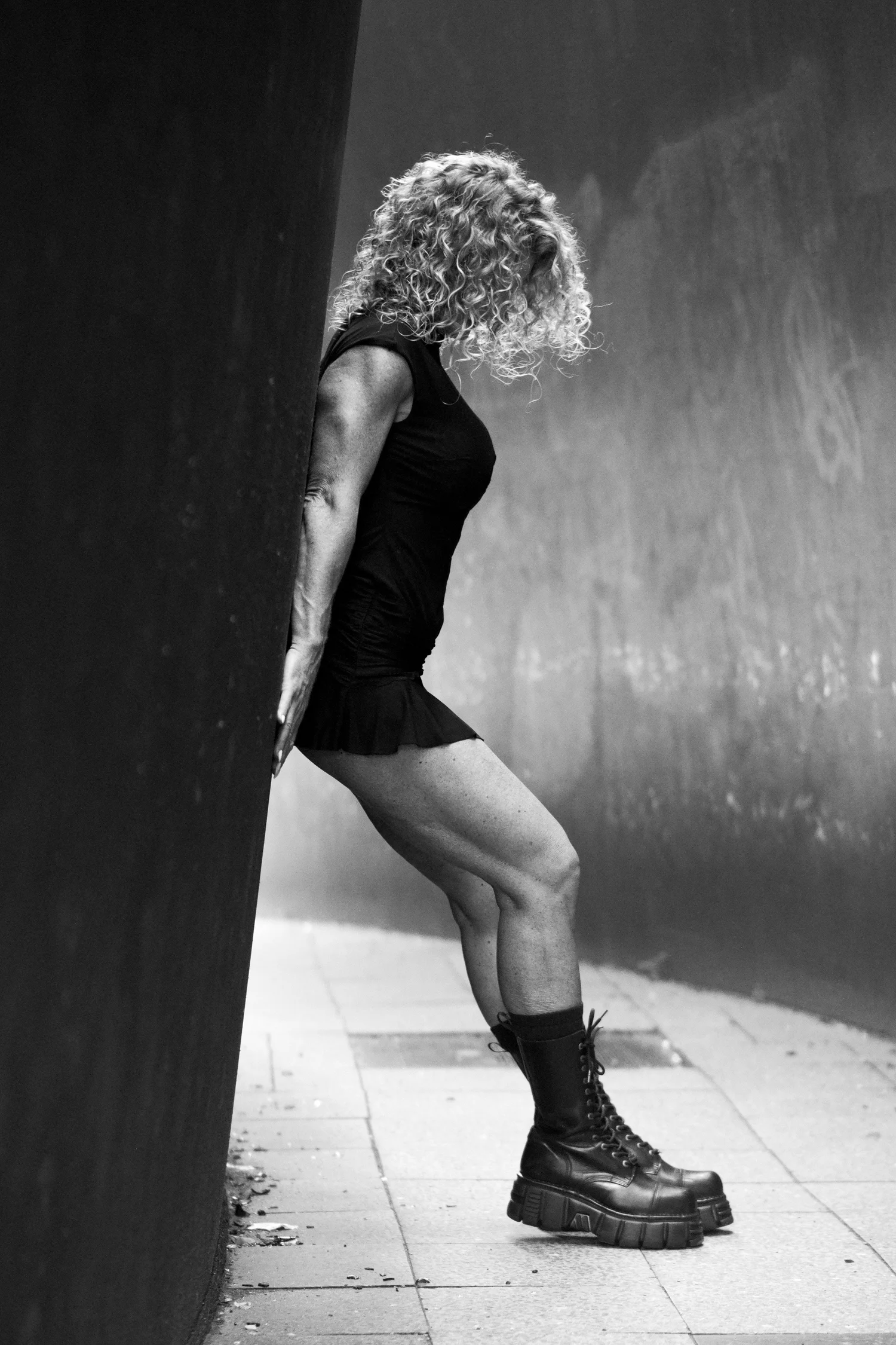 Chrisanna leaning against a steel wall in profile