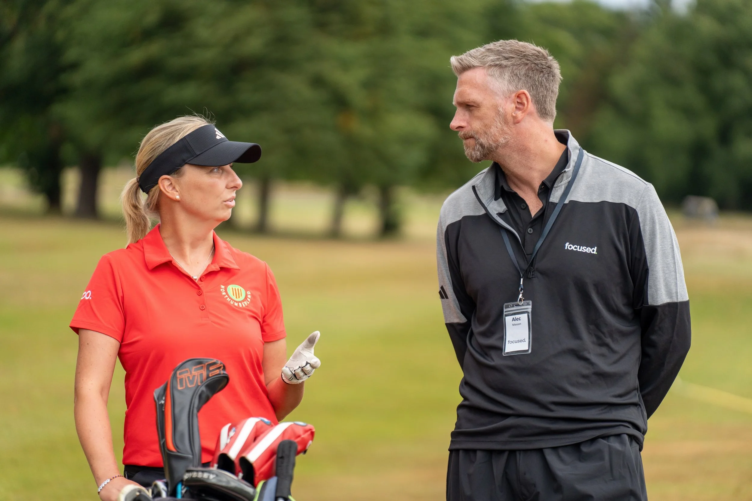 Focused Sport coach working with golfer on course