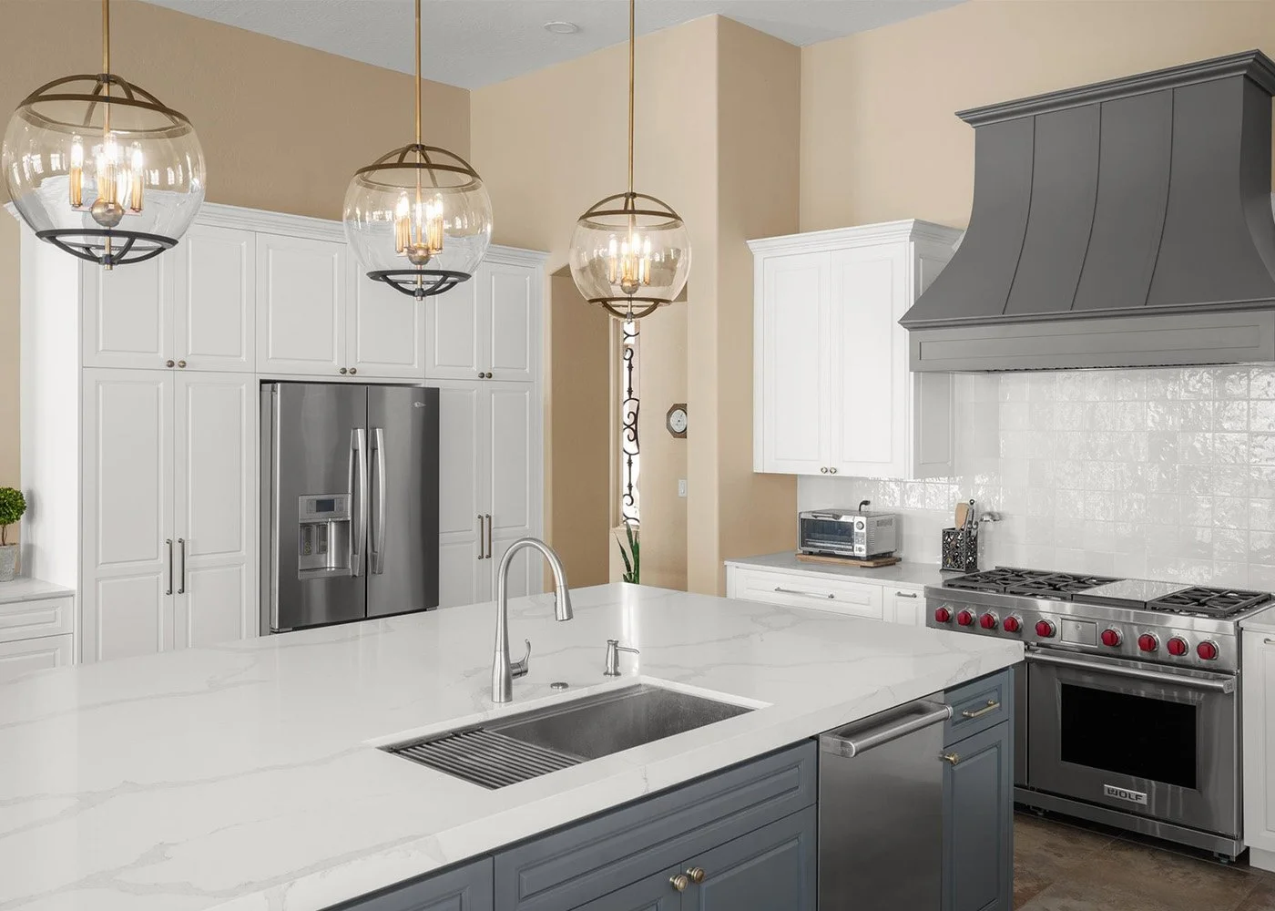 Scottsdale kitchen design with blue island, white cabinetry, globe pendant lights, and Wolf range