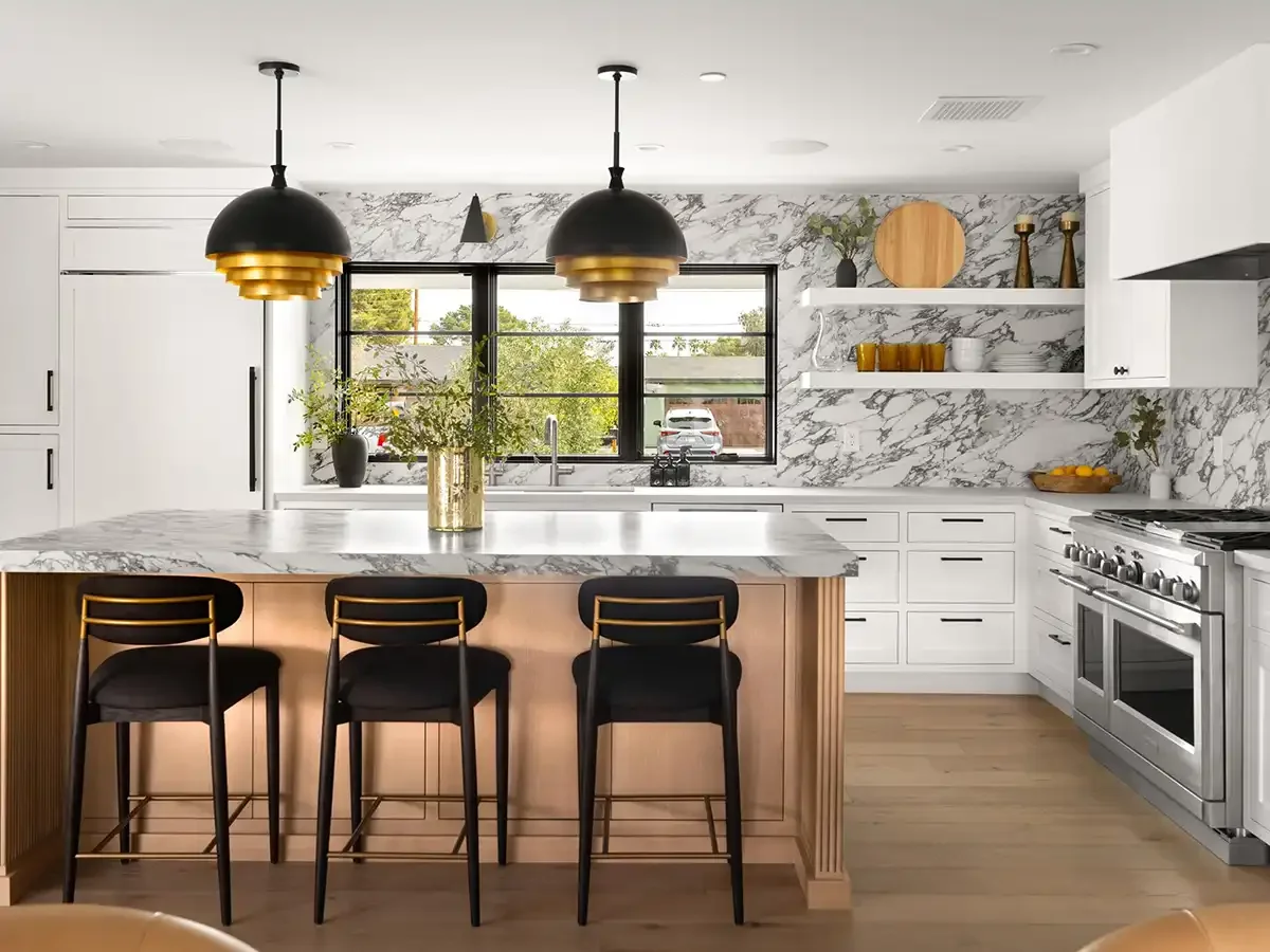 Modern white Scottsdale kitchen with marble backsplash, black pendant lights, and wood island