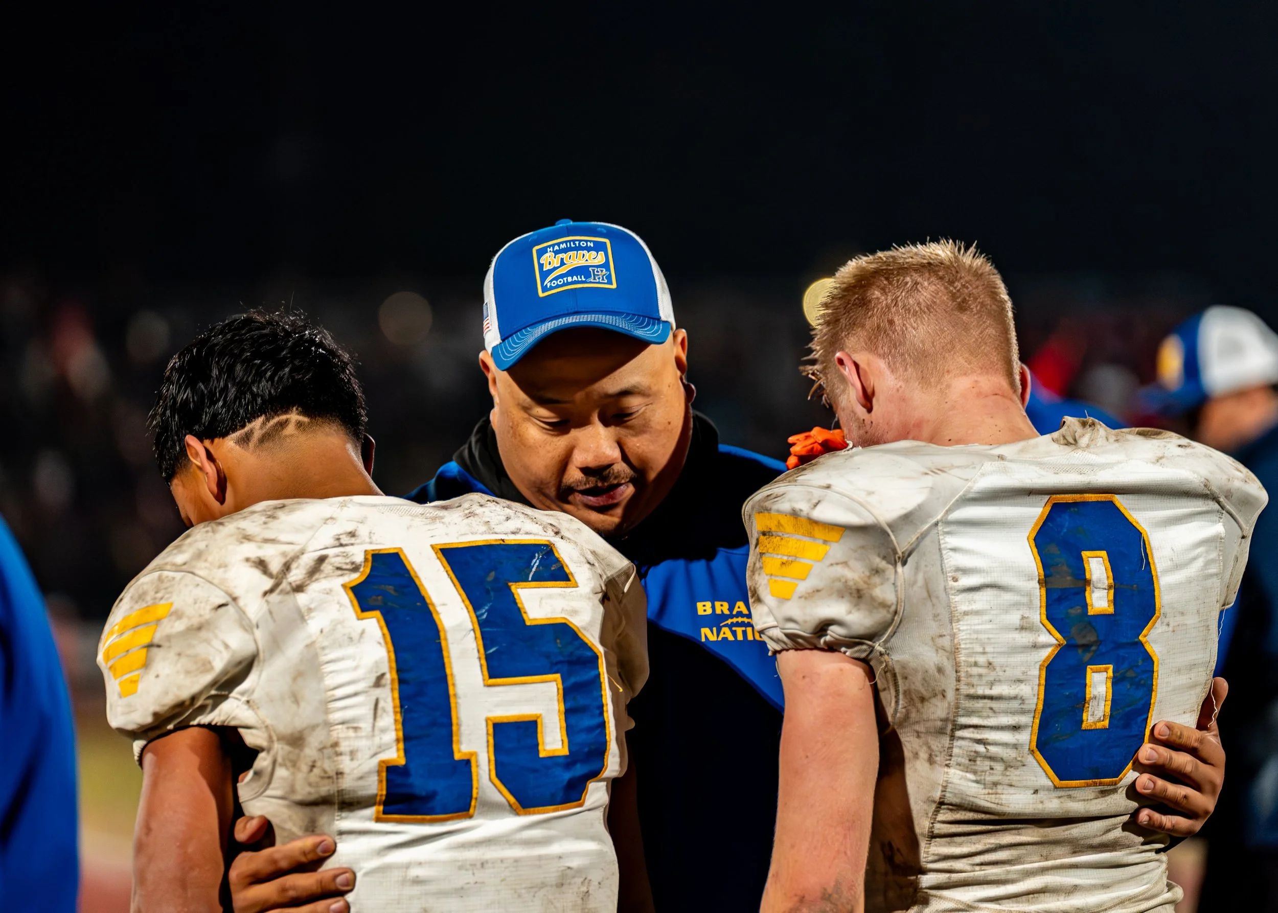 Hamilton players hug assistant coach Timothy Bushard after the championship game