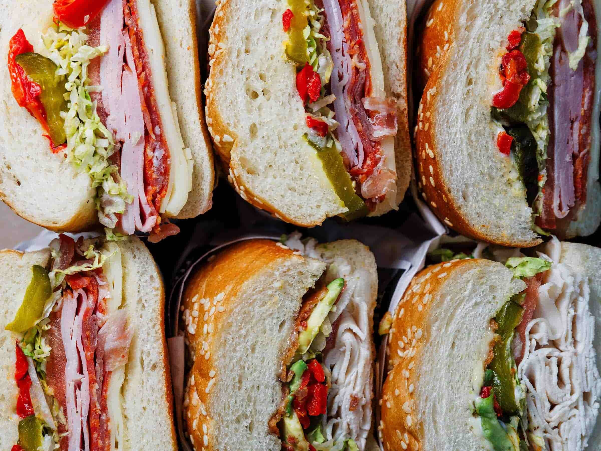 Brett's Deli sandwich spread with various sandwiches and sides