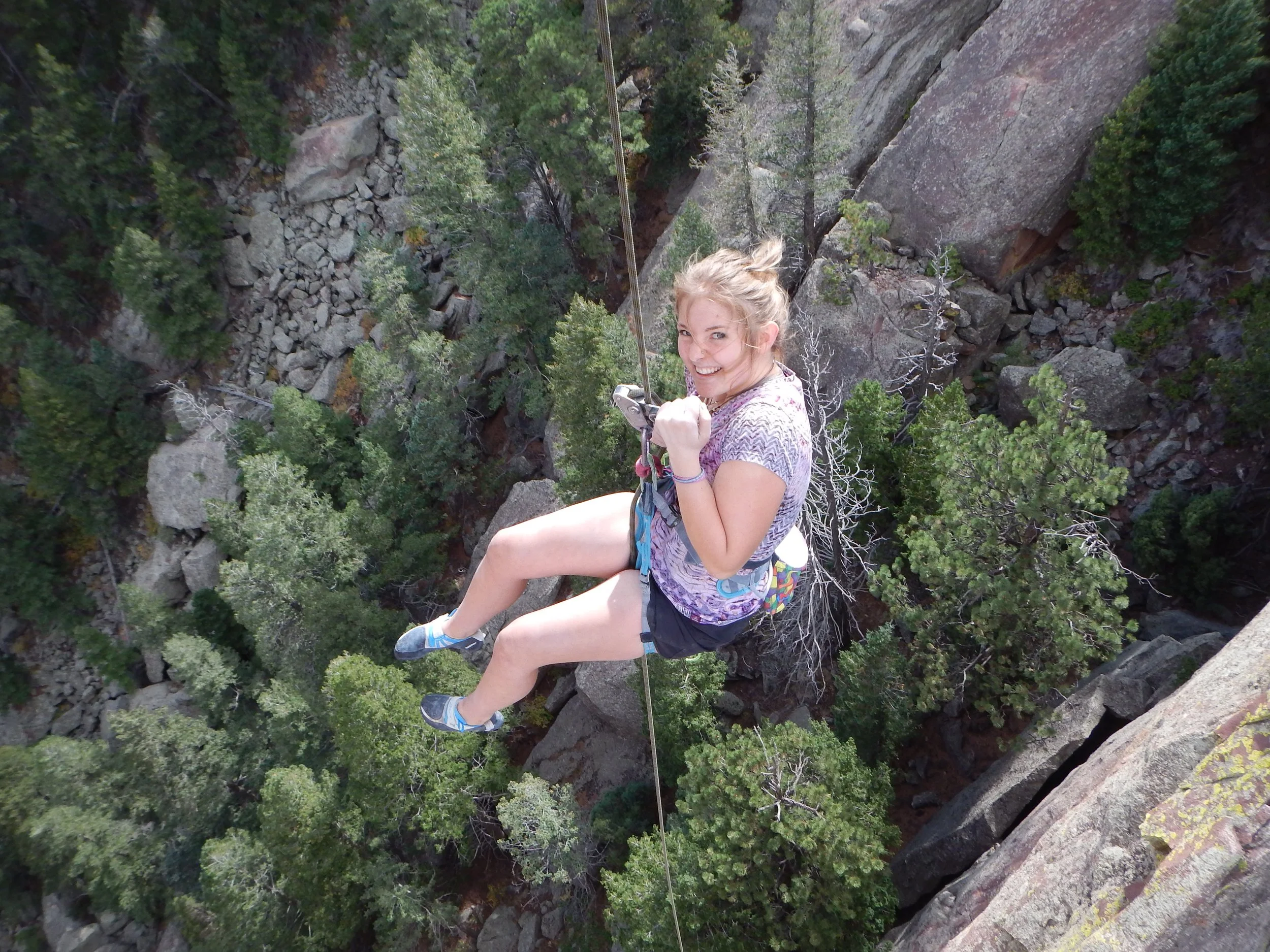 Beginner climber supported by a rope on exposed outdoor terrain near Boulder