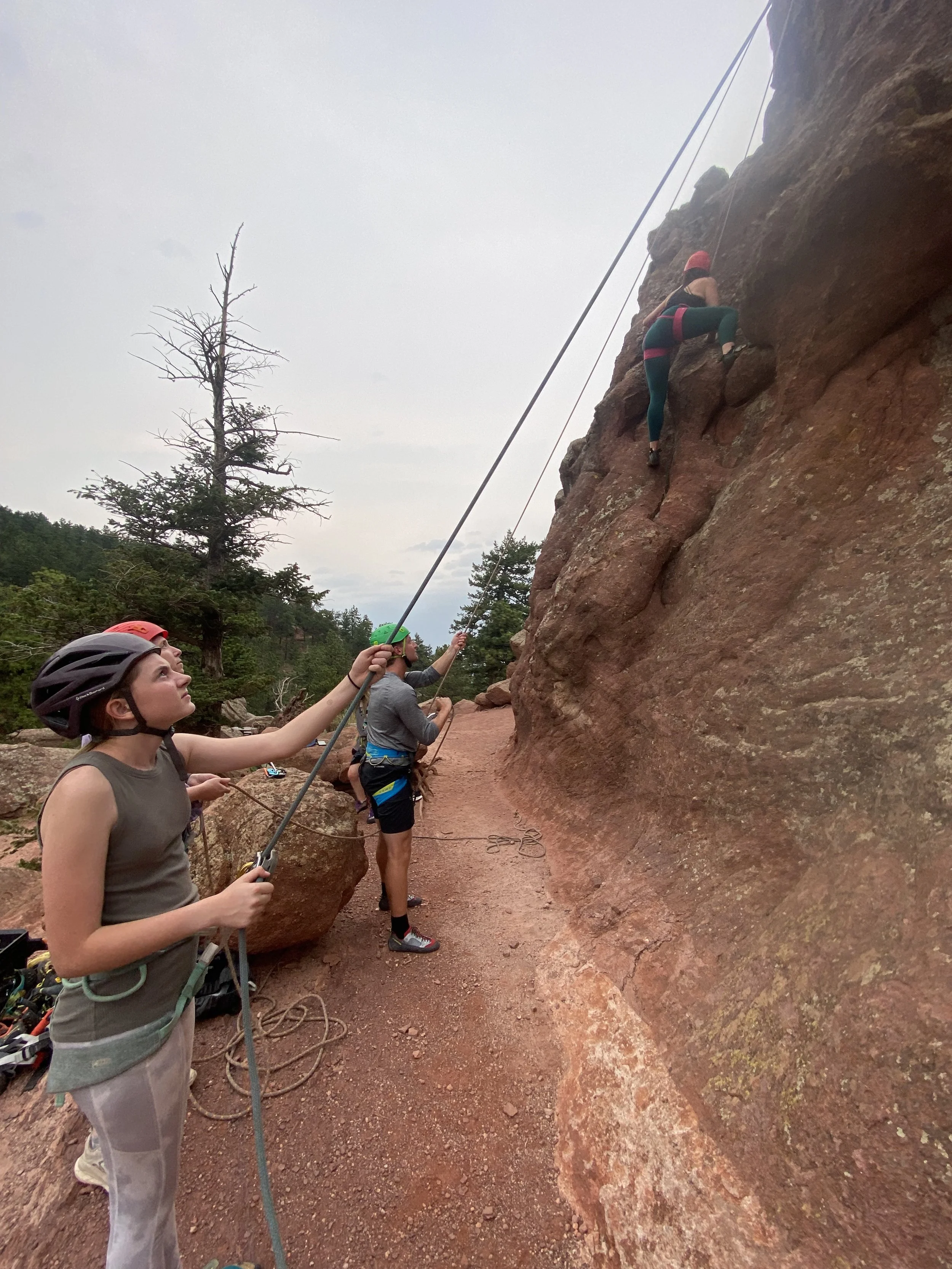 Beginner climber top-roping while partners belay on Flagstaff Mountain