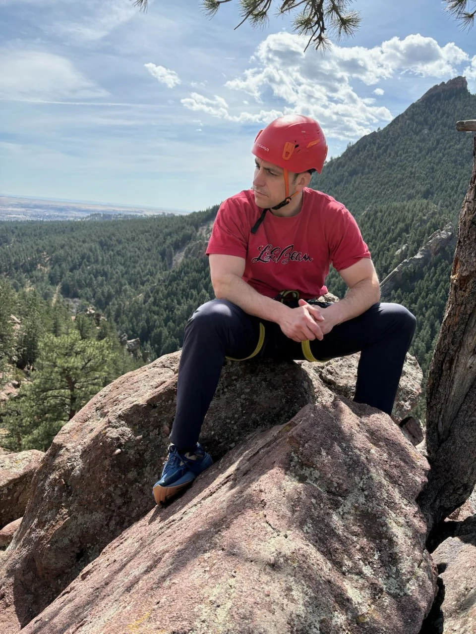 Climber resting on a Flagstaff Mountain rock with Boulder visible below