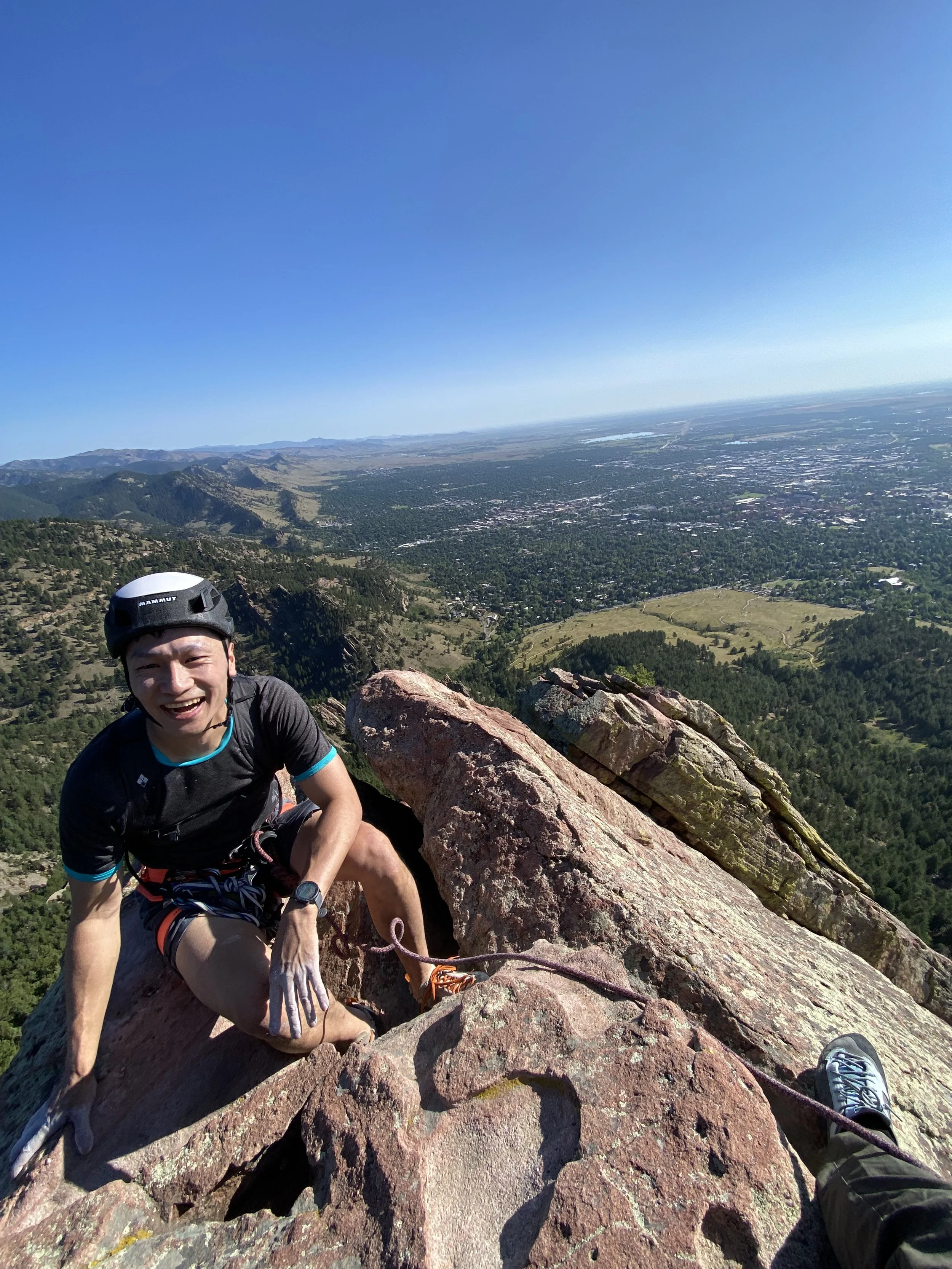 Climber high on a sandstone Flatiron above Boulder