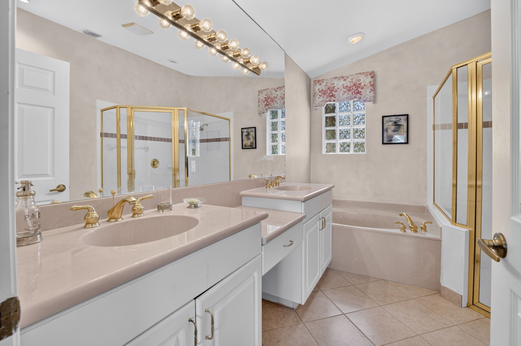 Primary bathroom with dual vanities and a Roman tub