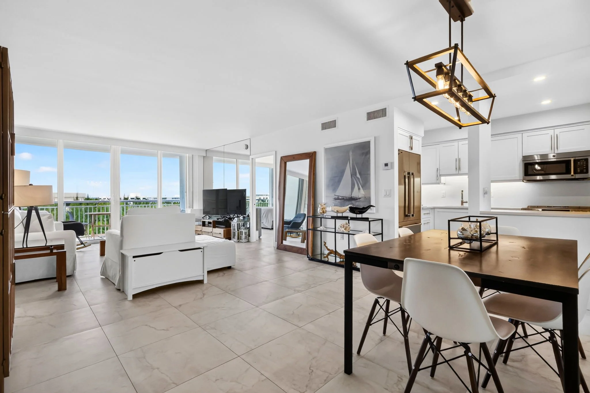 Open-concept living and dining area with mirrored accent wall