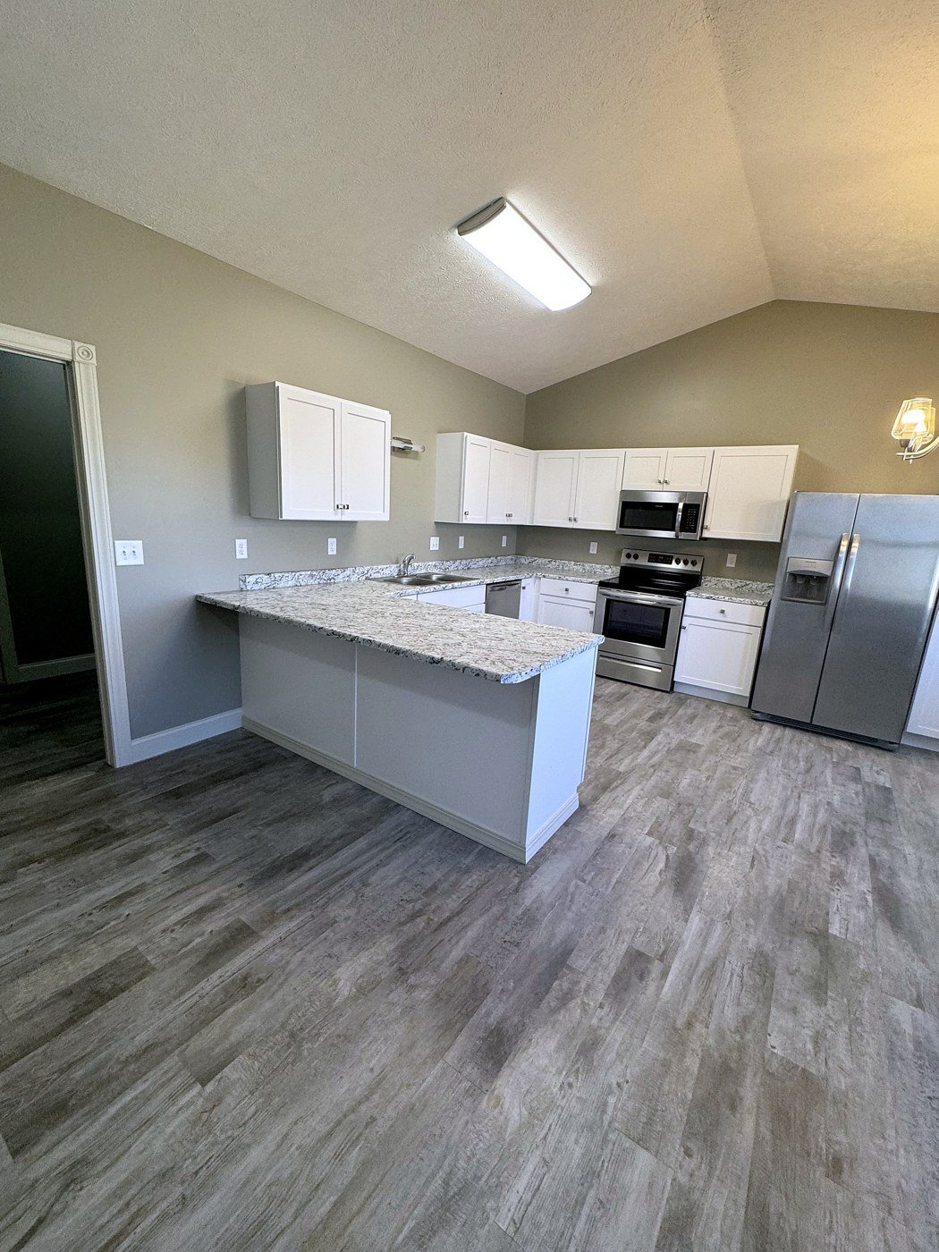 Two bedroom townhome kitchen with an island, white cabinets and stainless appliances