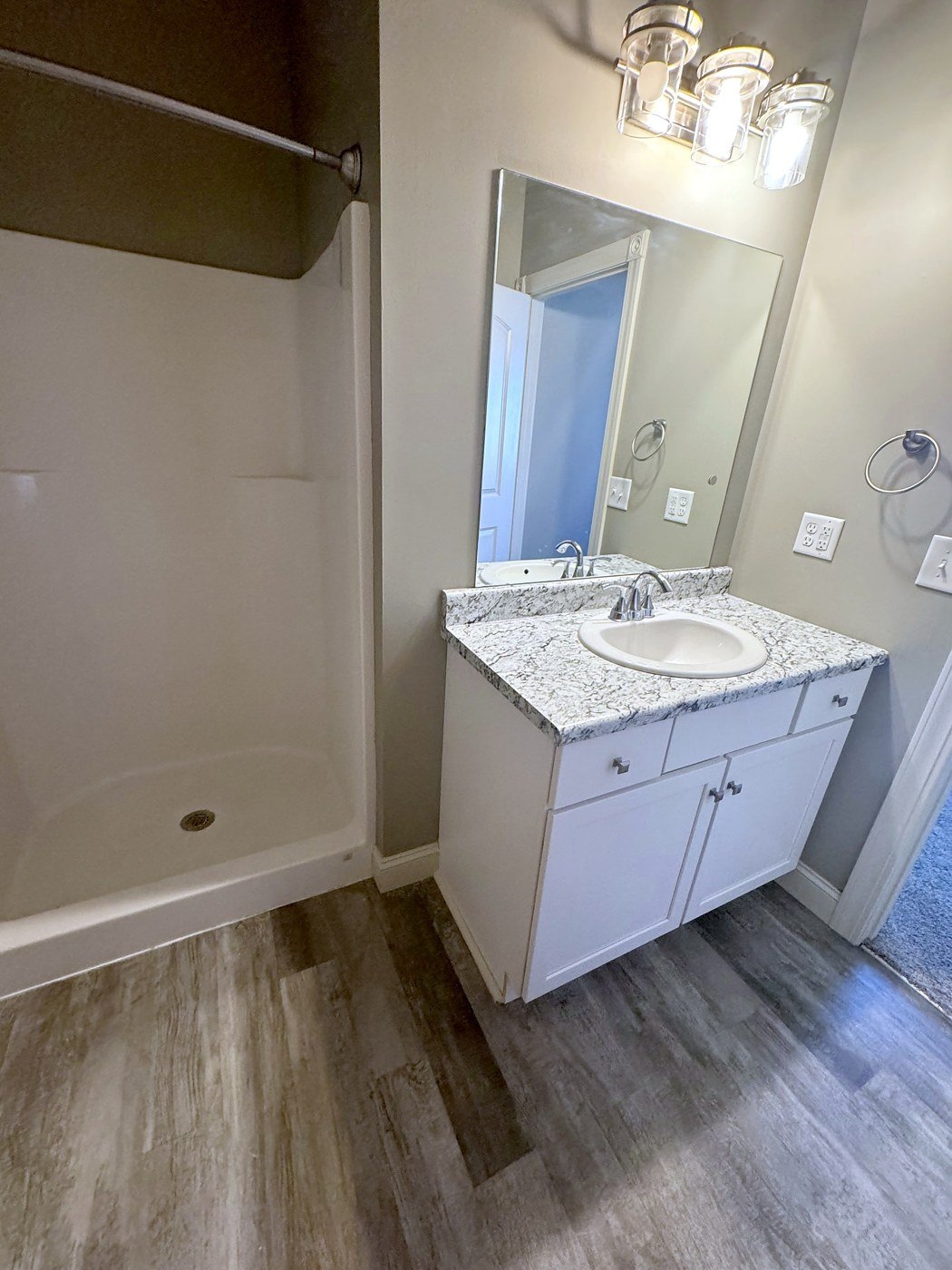 Full bath with a granite-topped vanity and walk-in shower