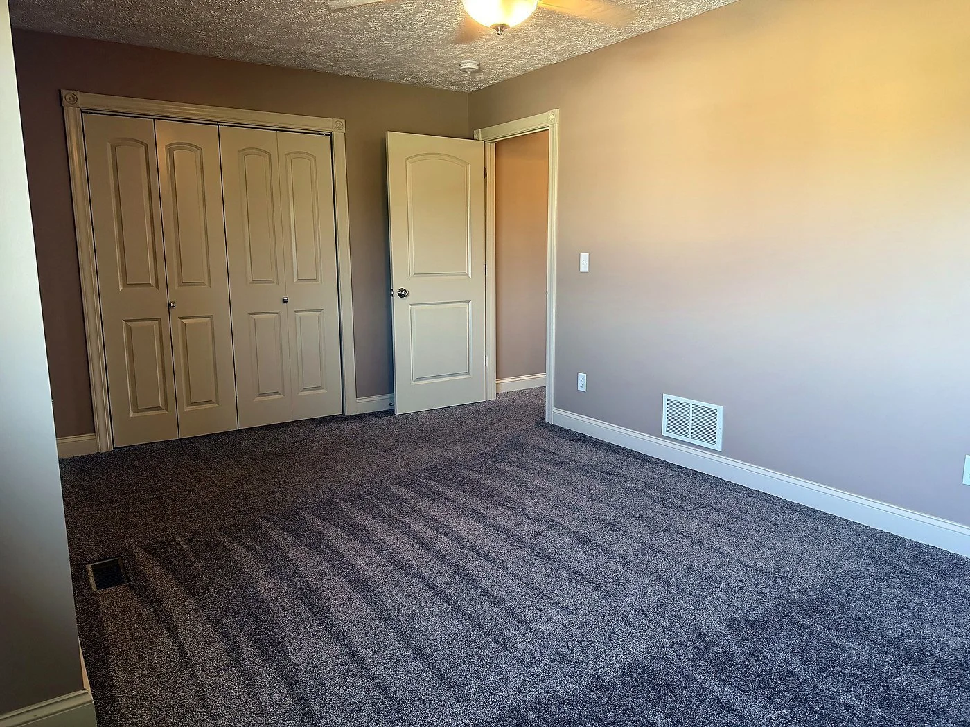 Carpeted bedroom with a ceiling fan