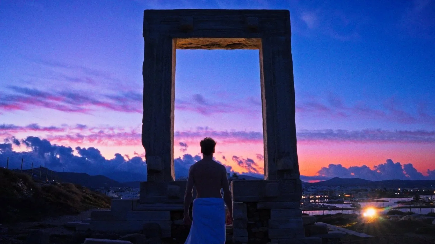 A man faces the Portara on Naxos at dusk