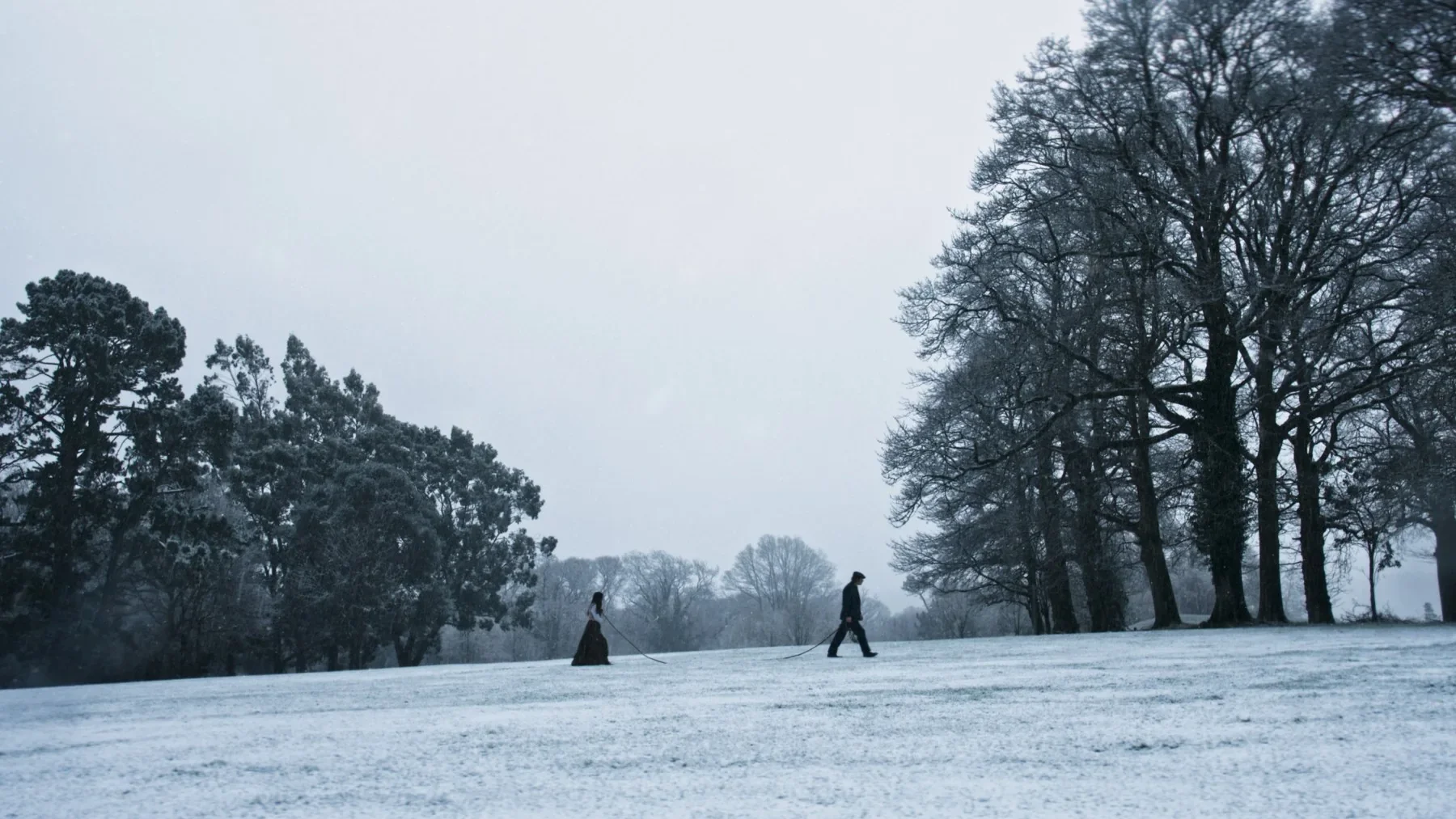 Two figures cross a snow-covered field in An Taibhse.